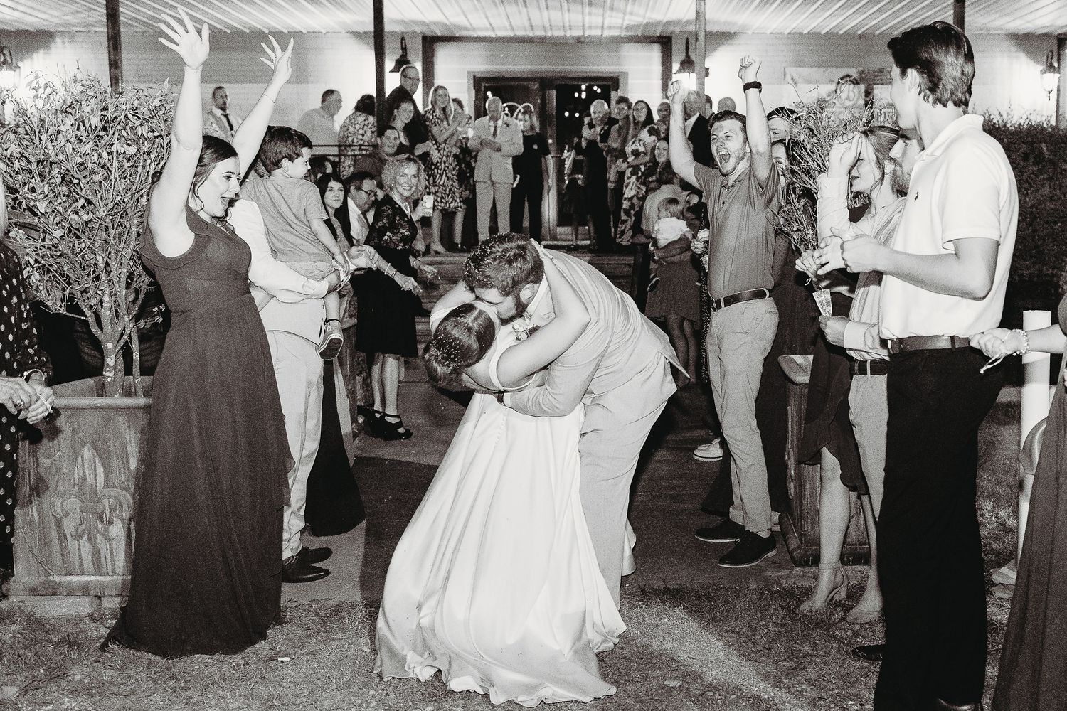 Black and white photos of wedding guests dancing and celebrating at a lively reception.
