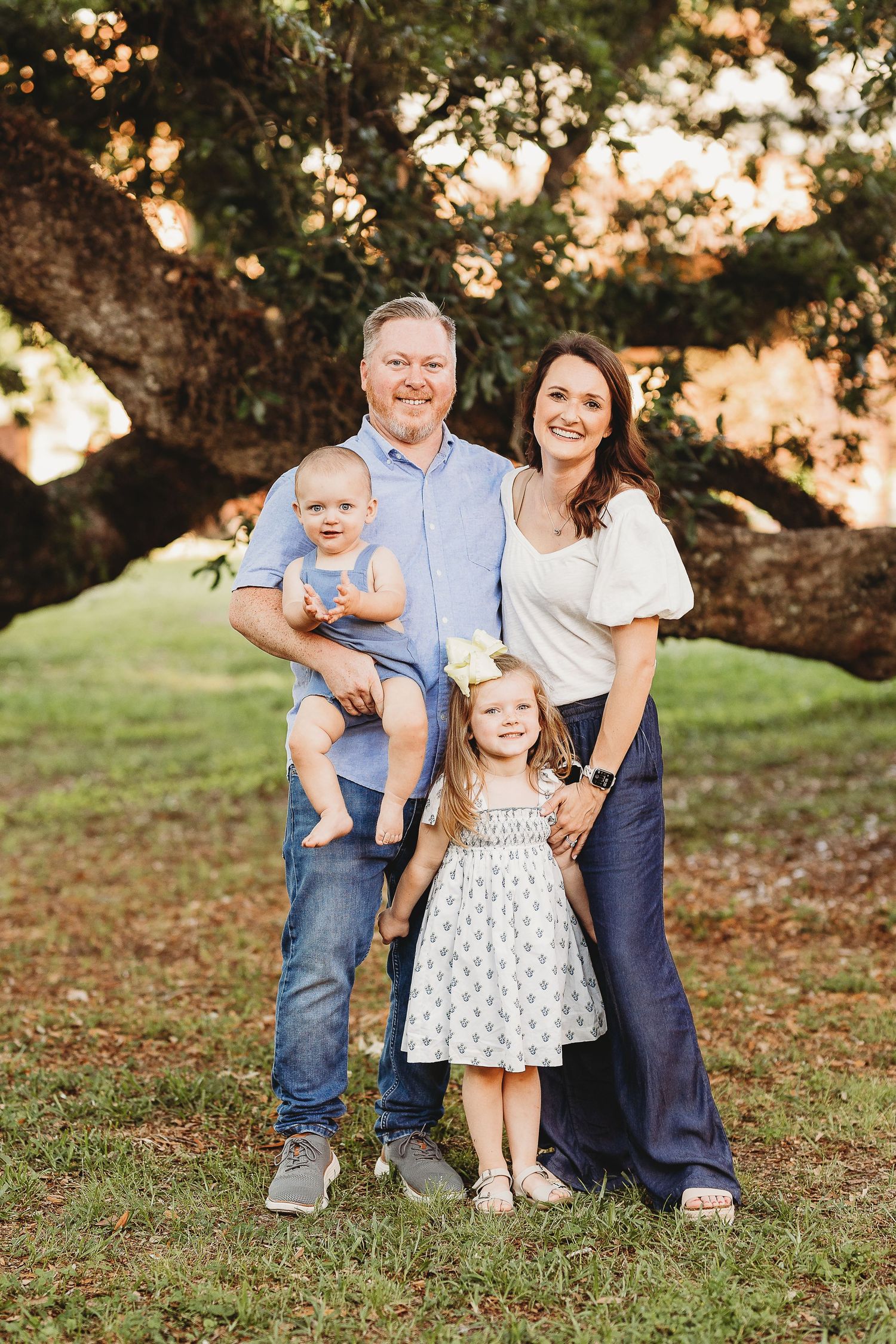 A family portrait captured at sunset under a majestic oak tree.