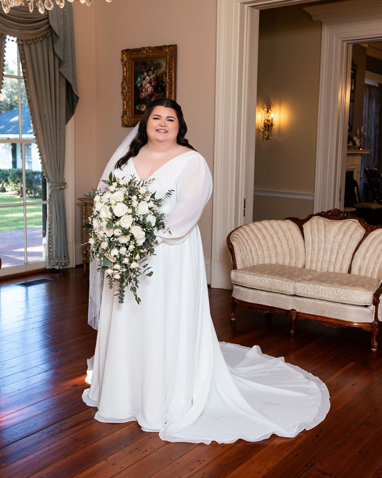 Elegant bridal portrait series showing white gown and floral arrangements in a luxurious room with hardwood floors.