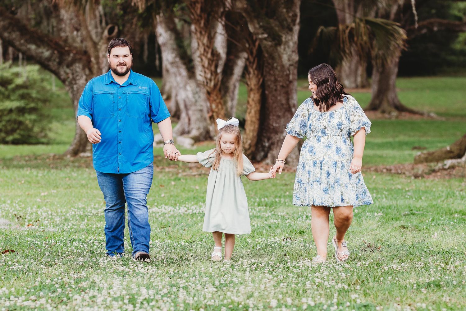 Family members strolling through park setting during outdoor photo session.