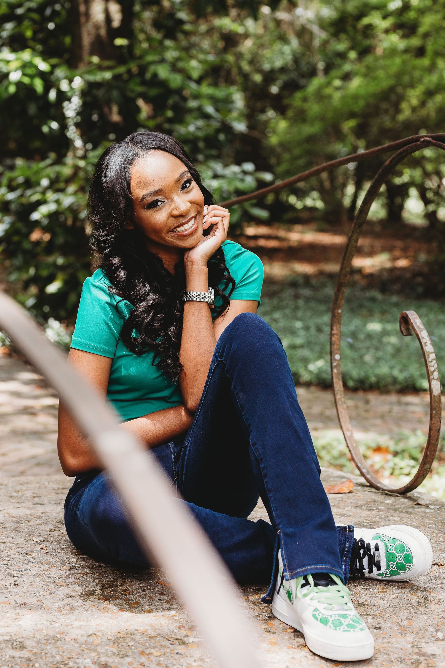 Relaxed outdoor portrait session with casual sneakers and natural greenery backdrop.