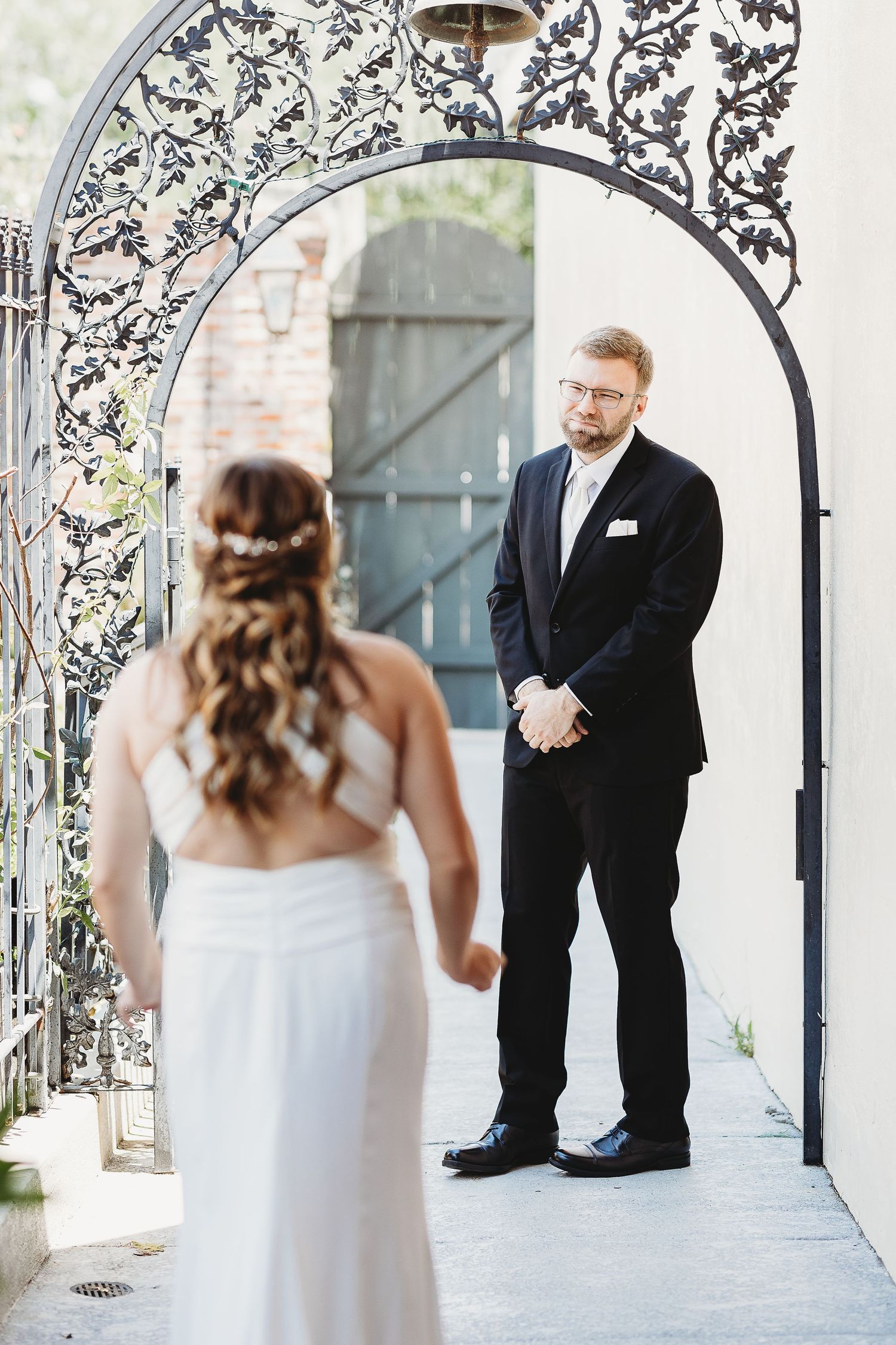 Romantic first look between couple under ornate black and white patterned archway.