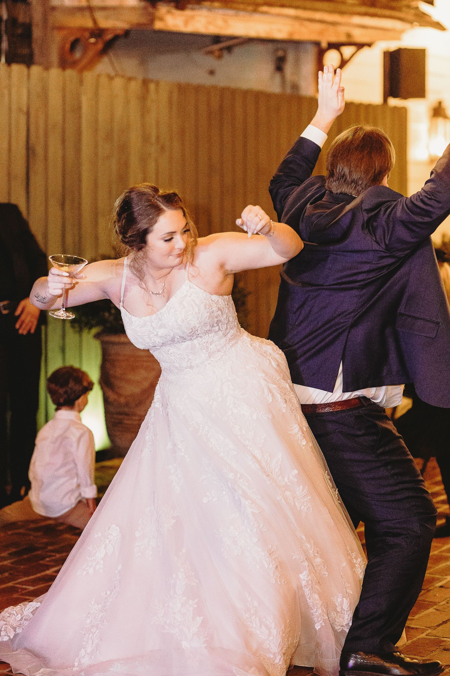 Wedding guests dance energetically during the reception celebration.