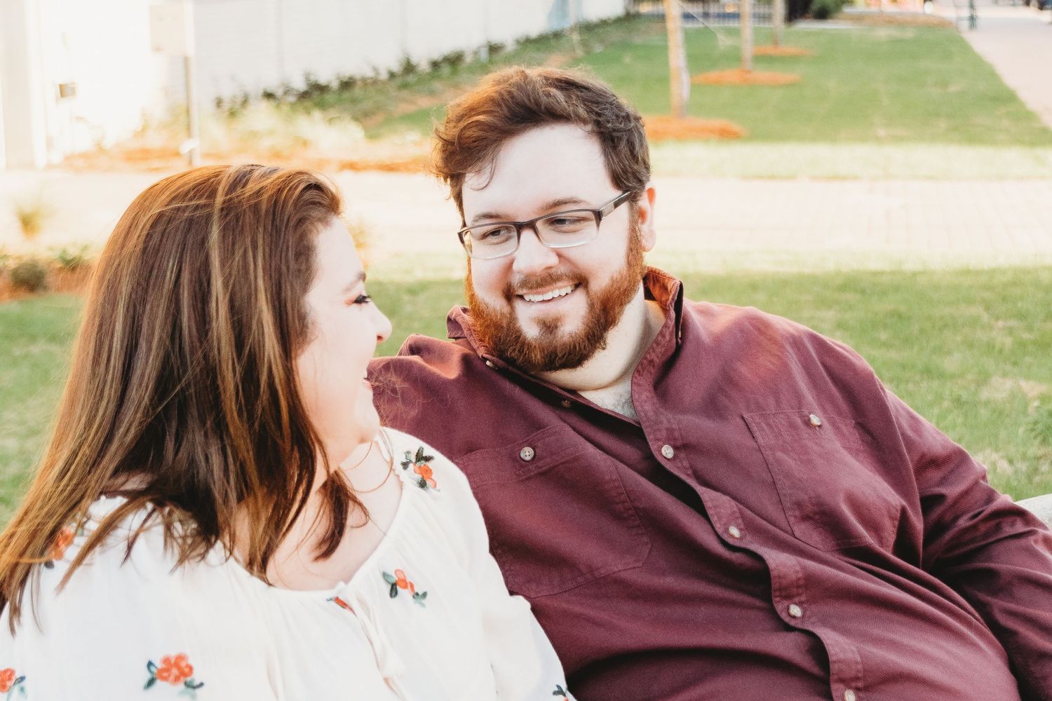 Couple in burgundy and white share intimate moments during outdoor portrait session.