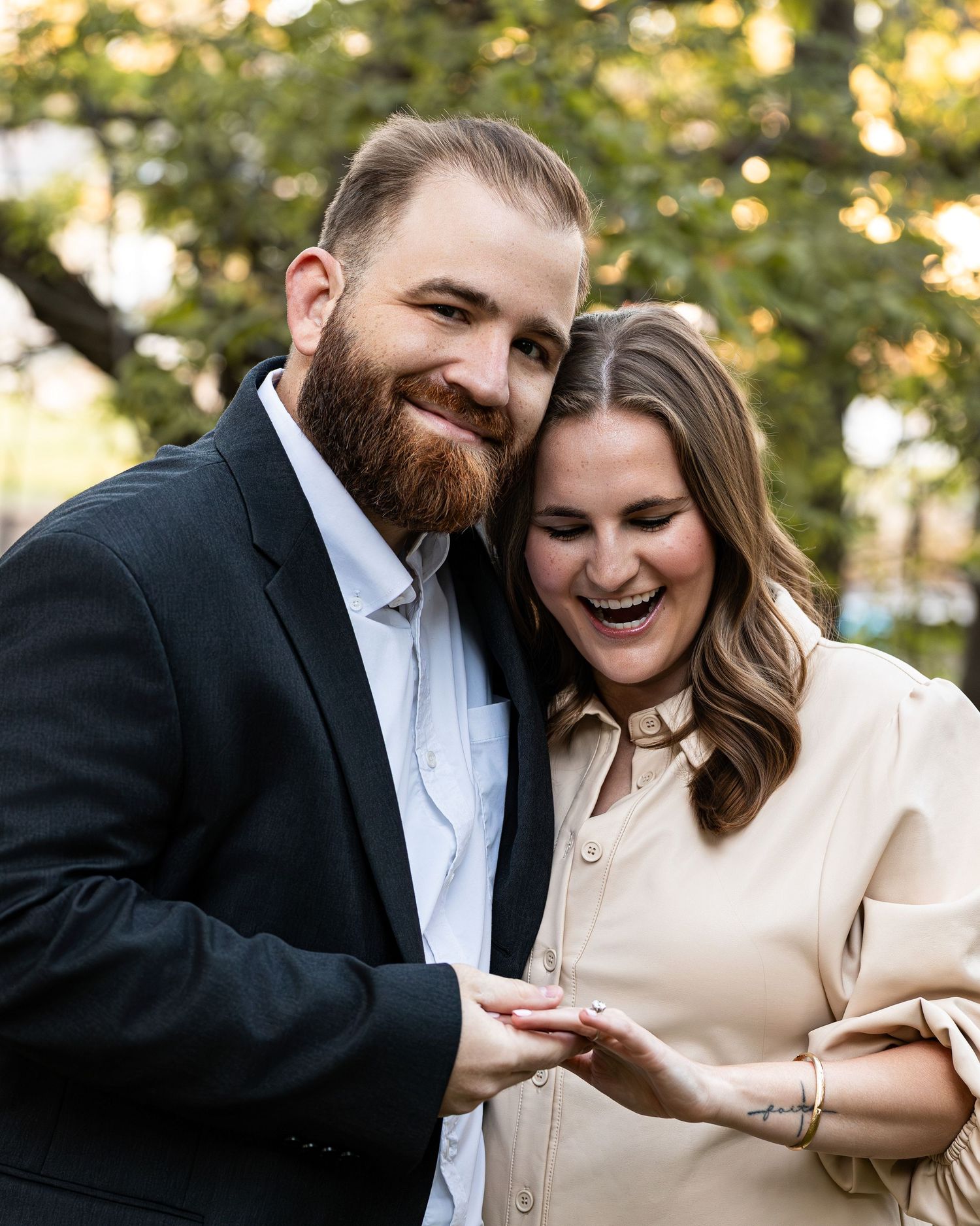 A joyful couple shares a candid moment together outdoors during an autumn photoshoot.