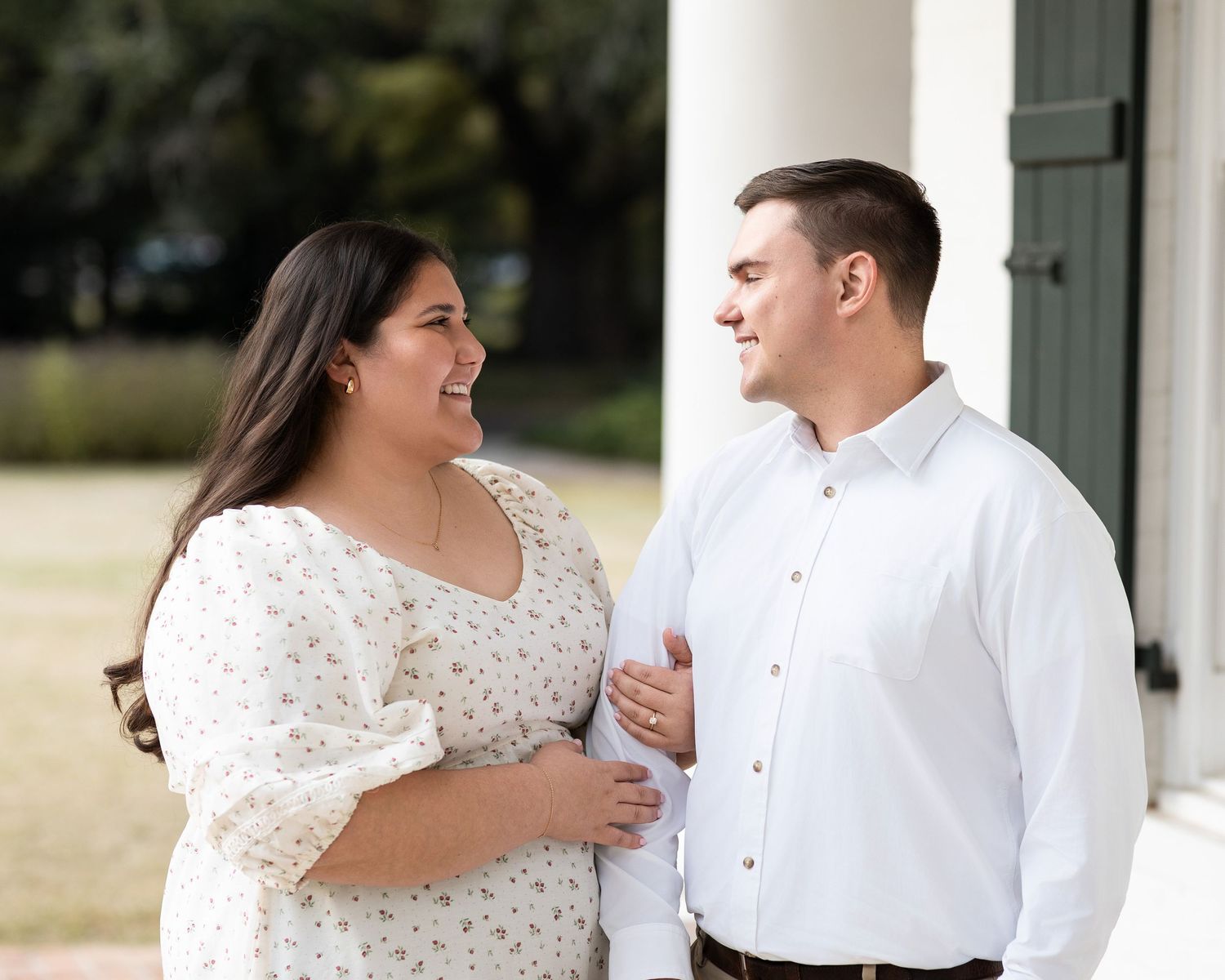 A couple in wedding attire shares a joyful moment together during an outdoor photo session.