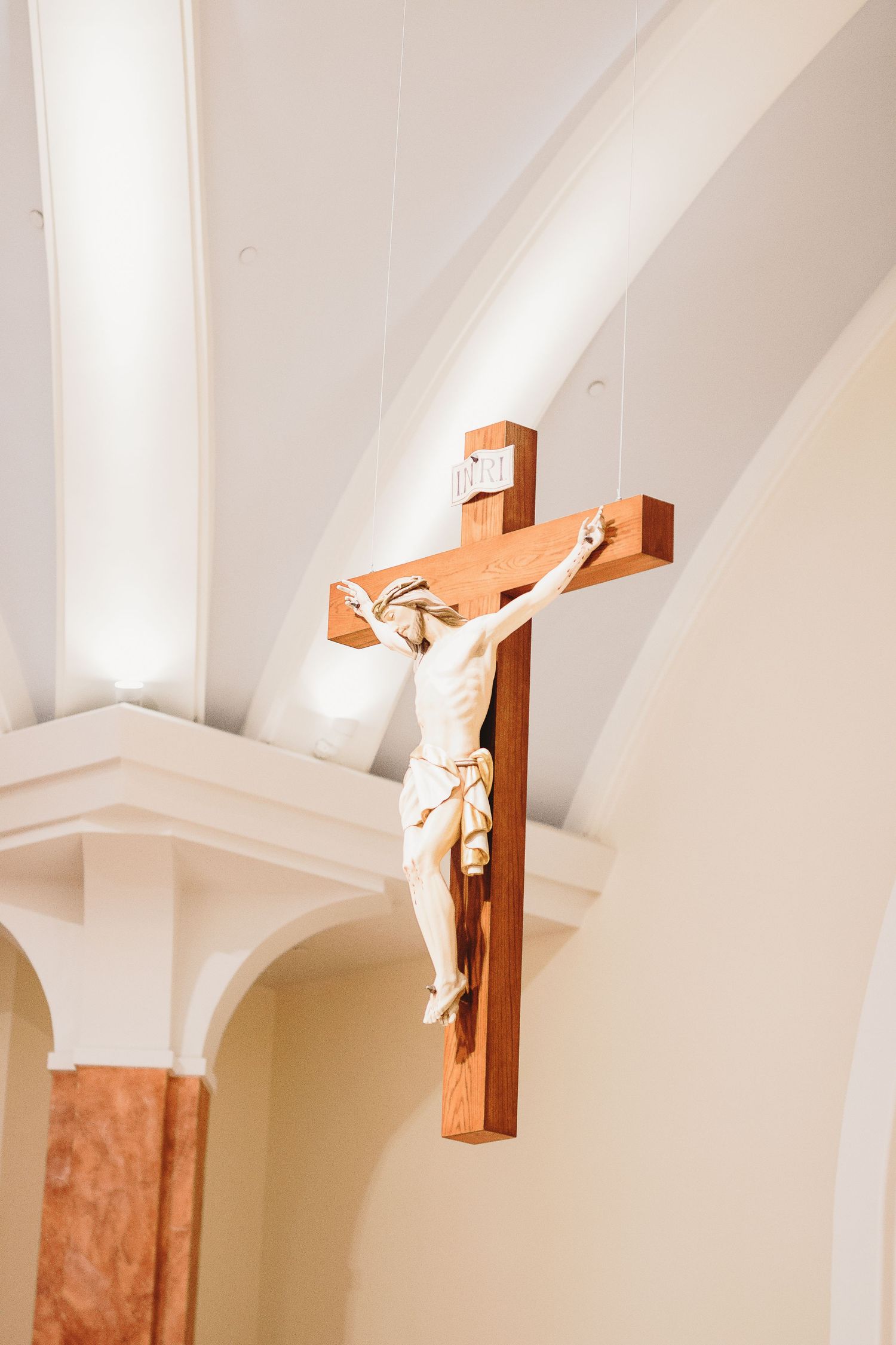 Wooden crucifixes mounted on white walls in a church interior.