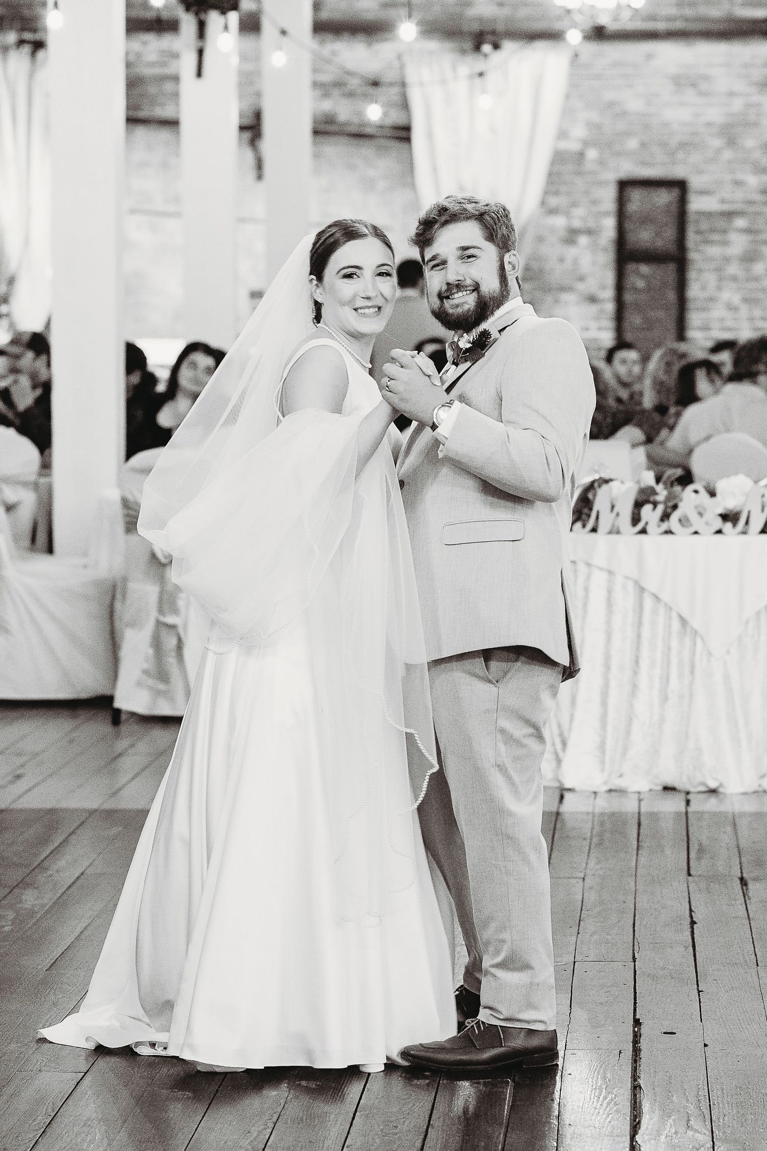 Black and white wedding dance photos showing joyful moments on a wooden floor.