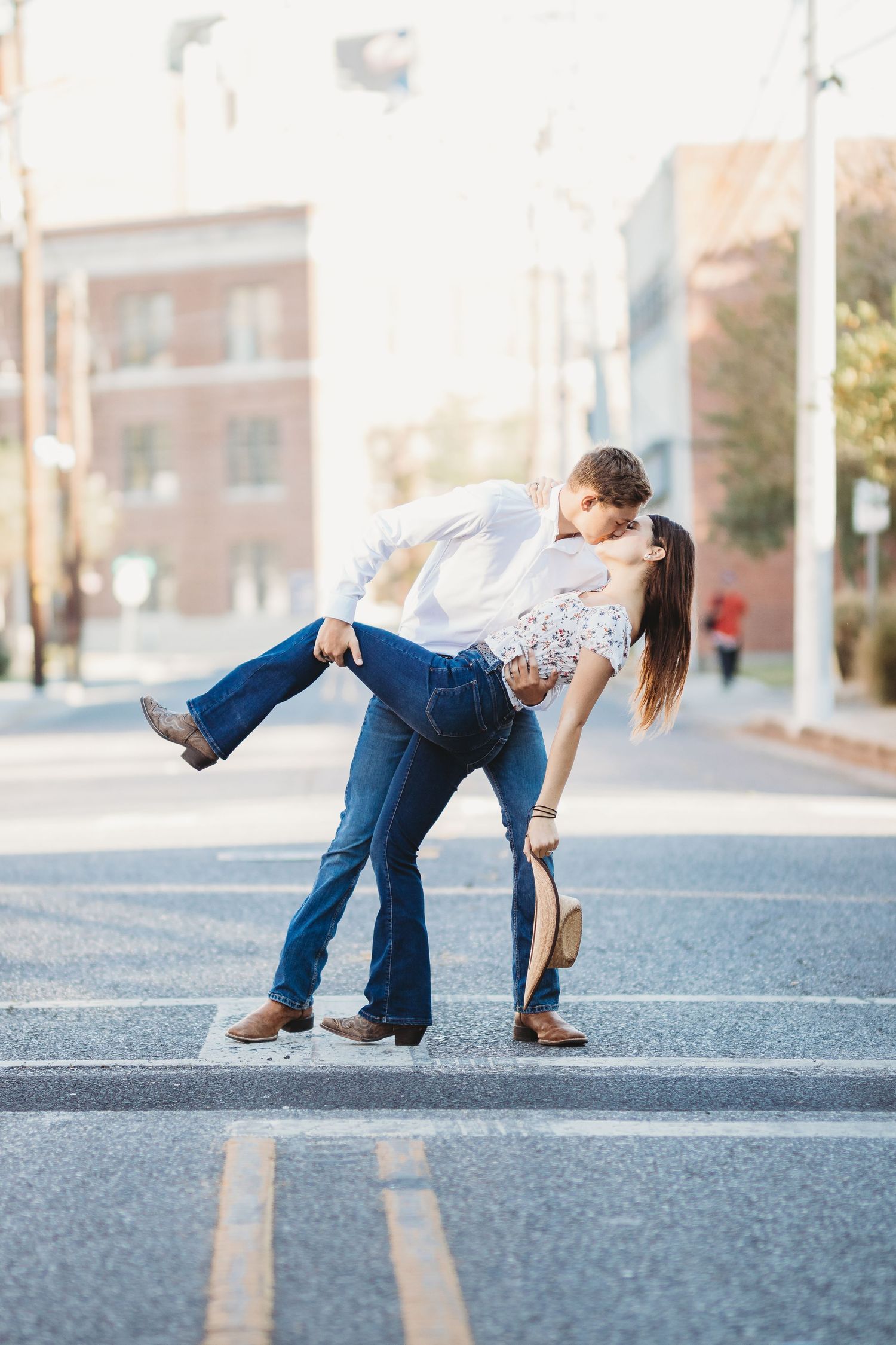 A couple performs a romantic dance dip pose in an empty street.