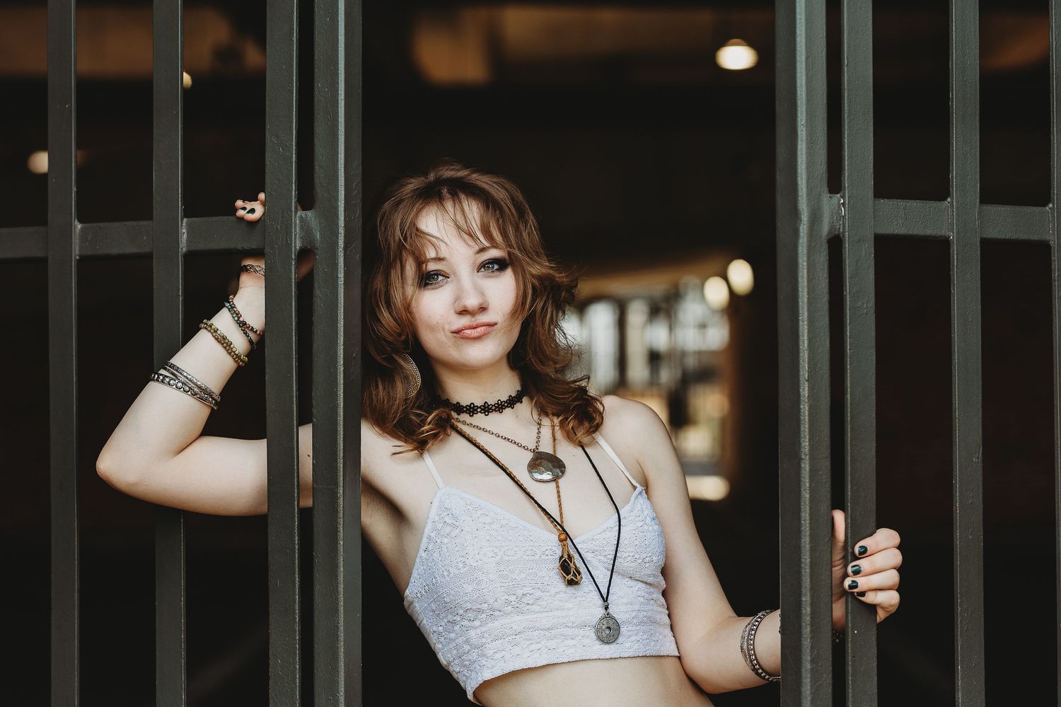 Fashion portrait with model posing between metal door frames in urban setting.