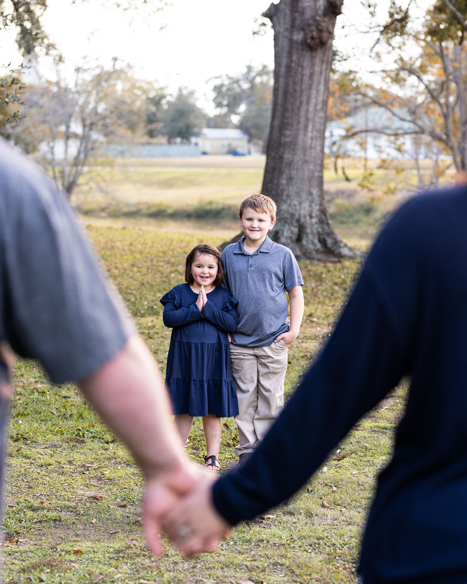 A casual outdoor photo session captured in a park setting during autumn.