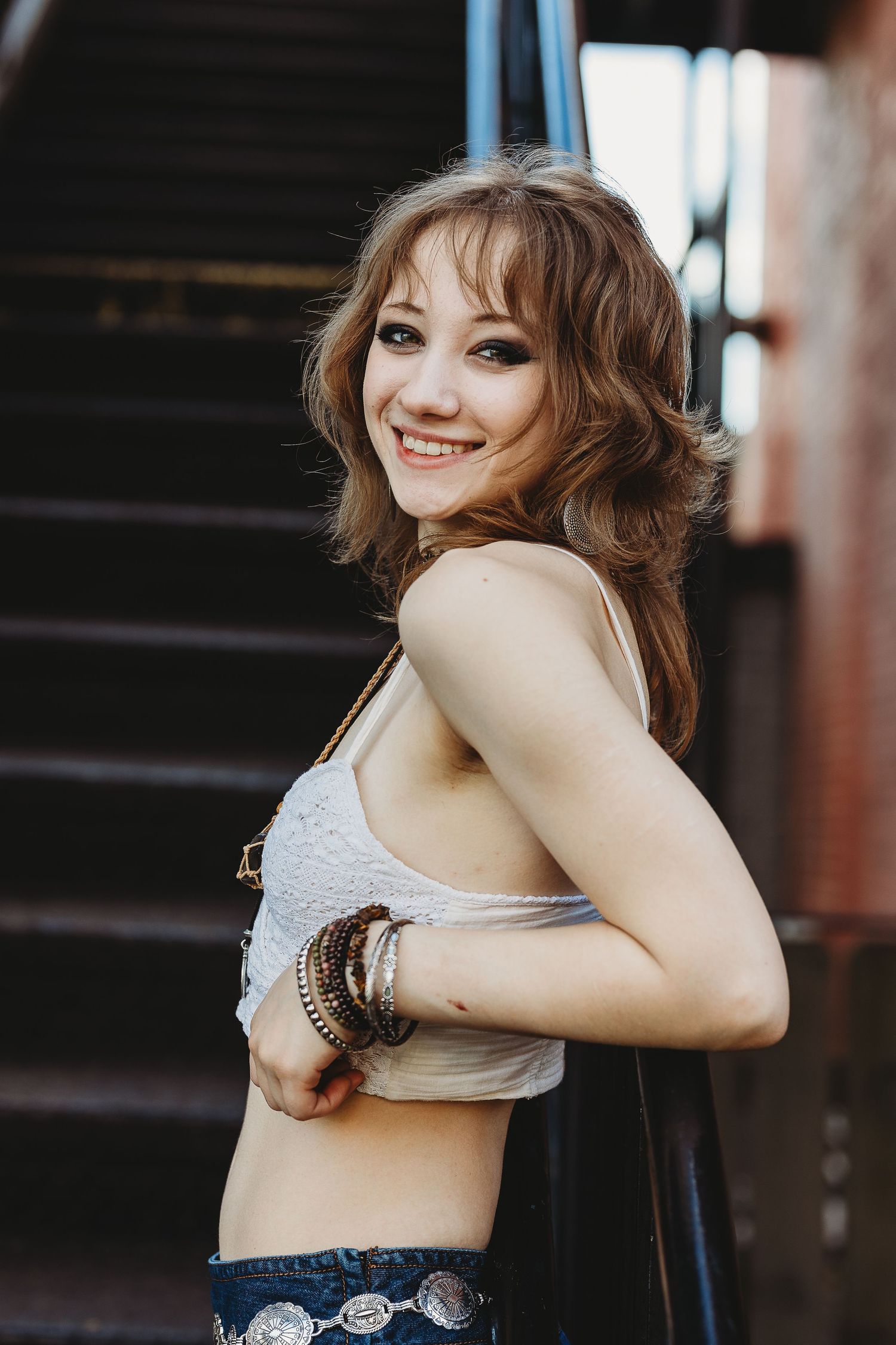 Casual fashion portrait on industrial staircase with natural lighting.
