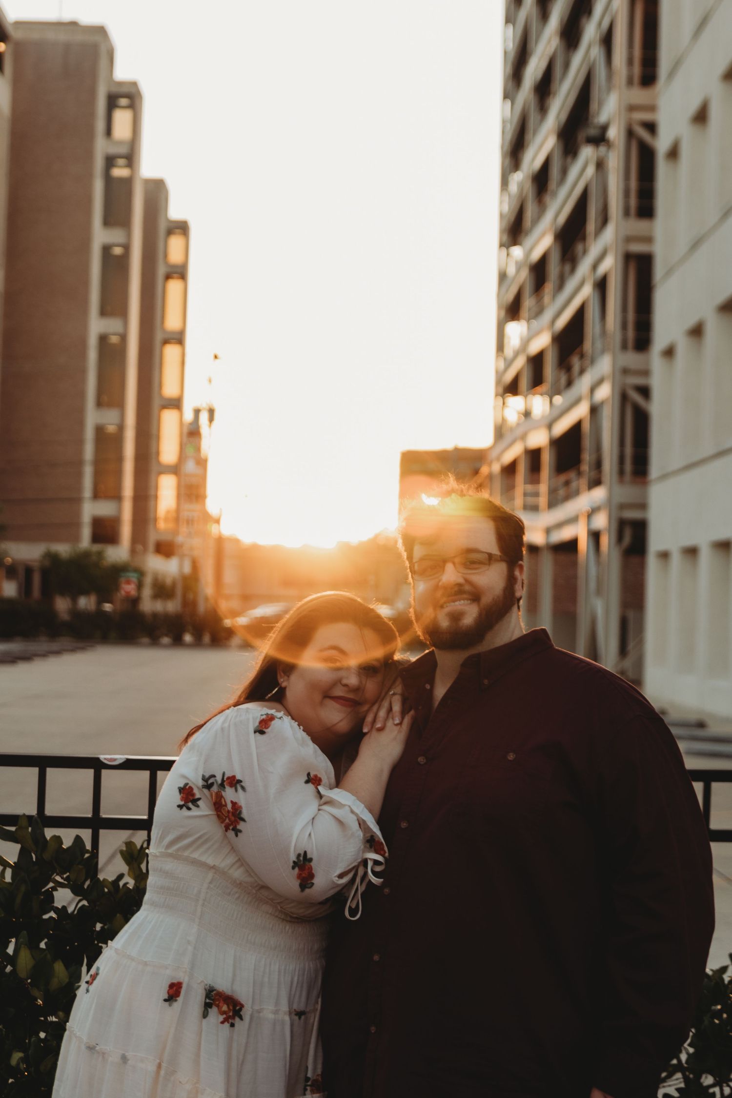 A romantic sunset photoshoot with a couple against an urban backdrop.