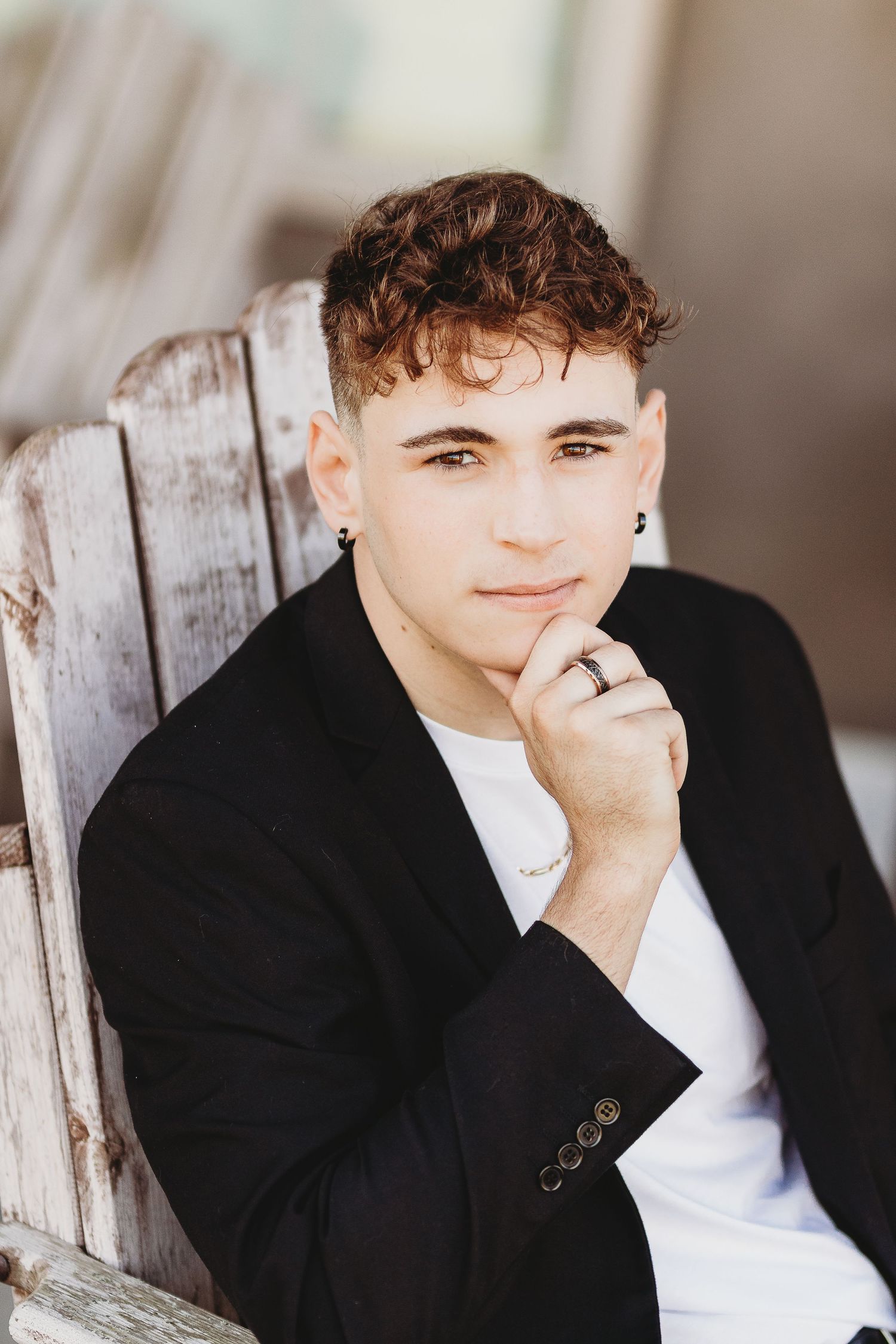 Professional headshot series against rustic wood backdrop wearing black blazer.
