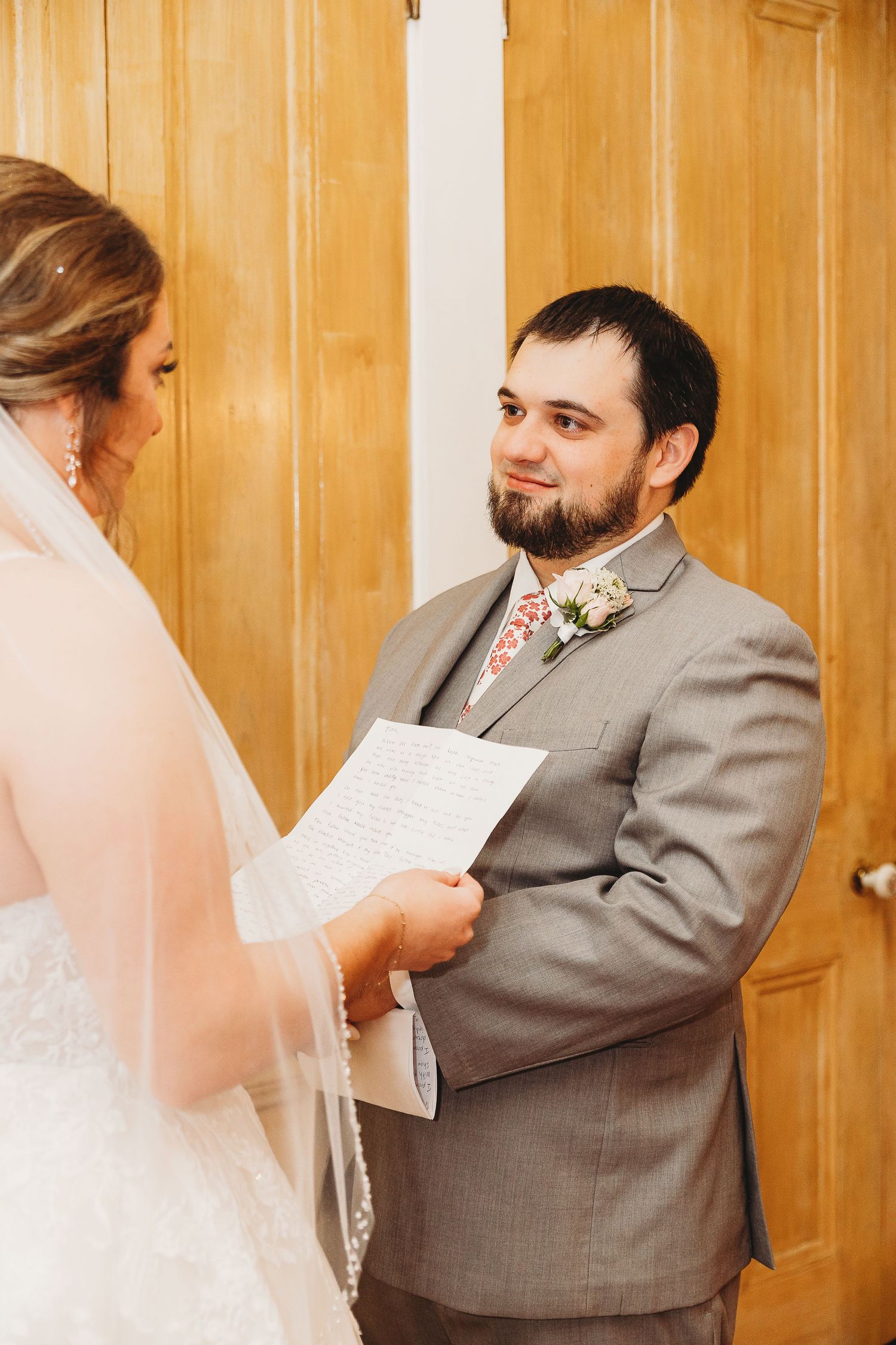 A tender moment as the couple exchanges handwritten vows during their wedding ceremony.