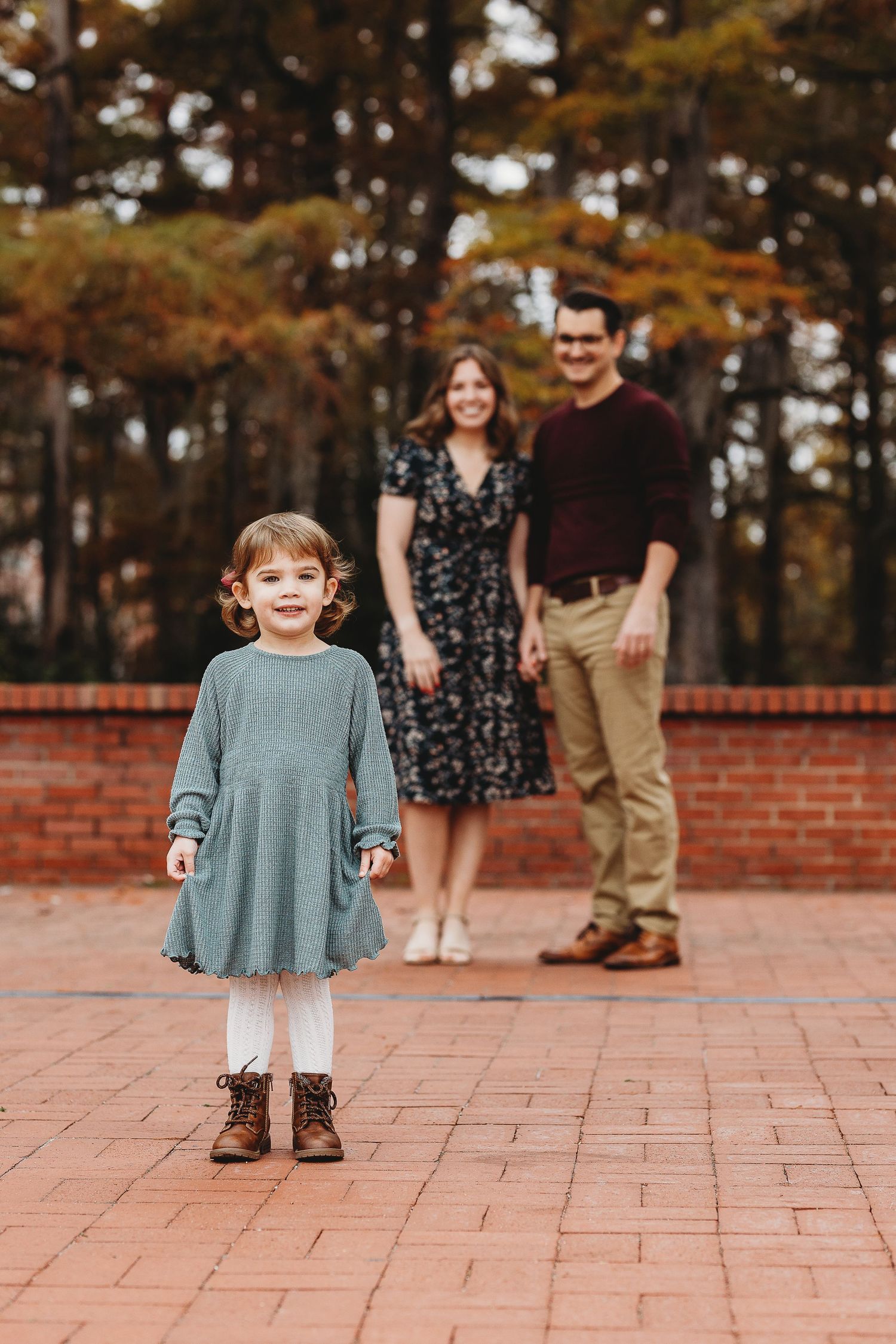 Playful moments captured on a brick patio during an autumn photo session.