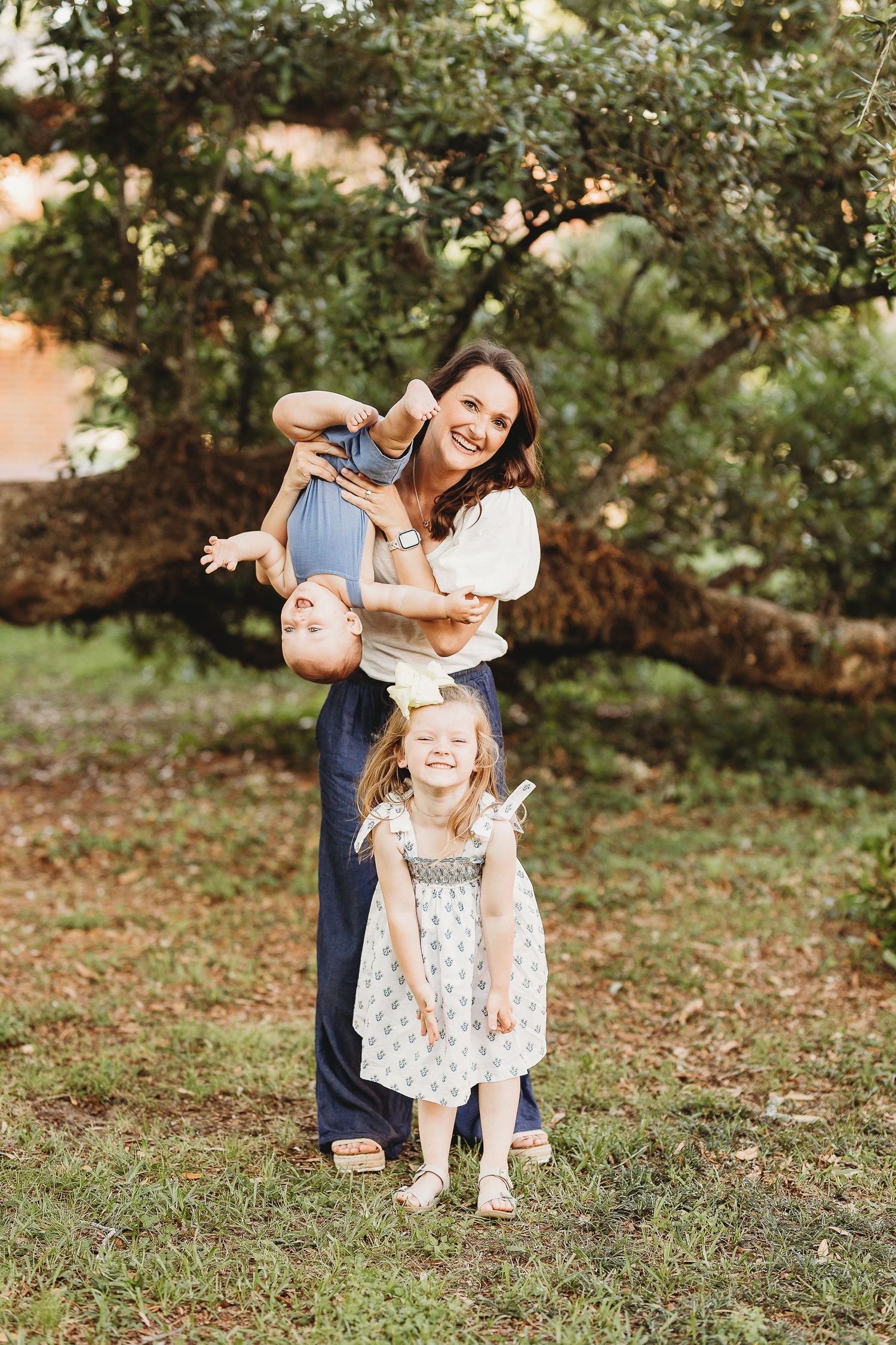 Family enjoying playful moments together in a natural outdoor setting during golden hour.