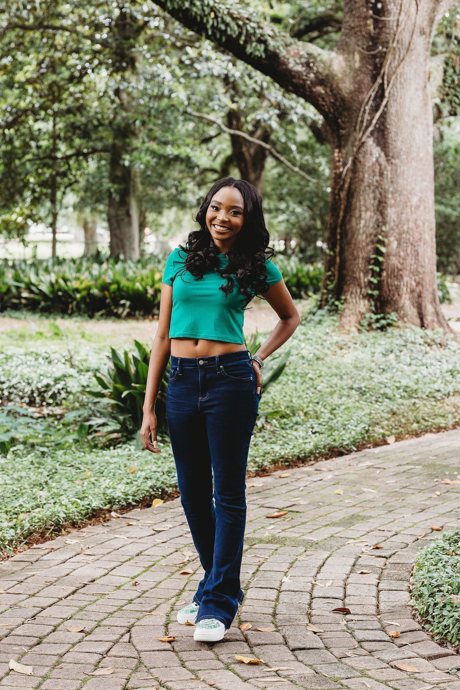 Natural outdoor photography session along a curved brick pathway surrounded by trees.