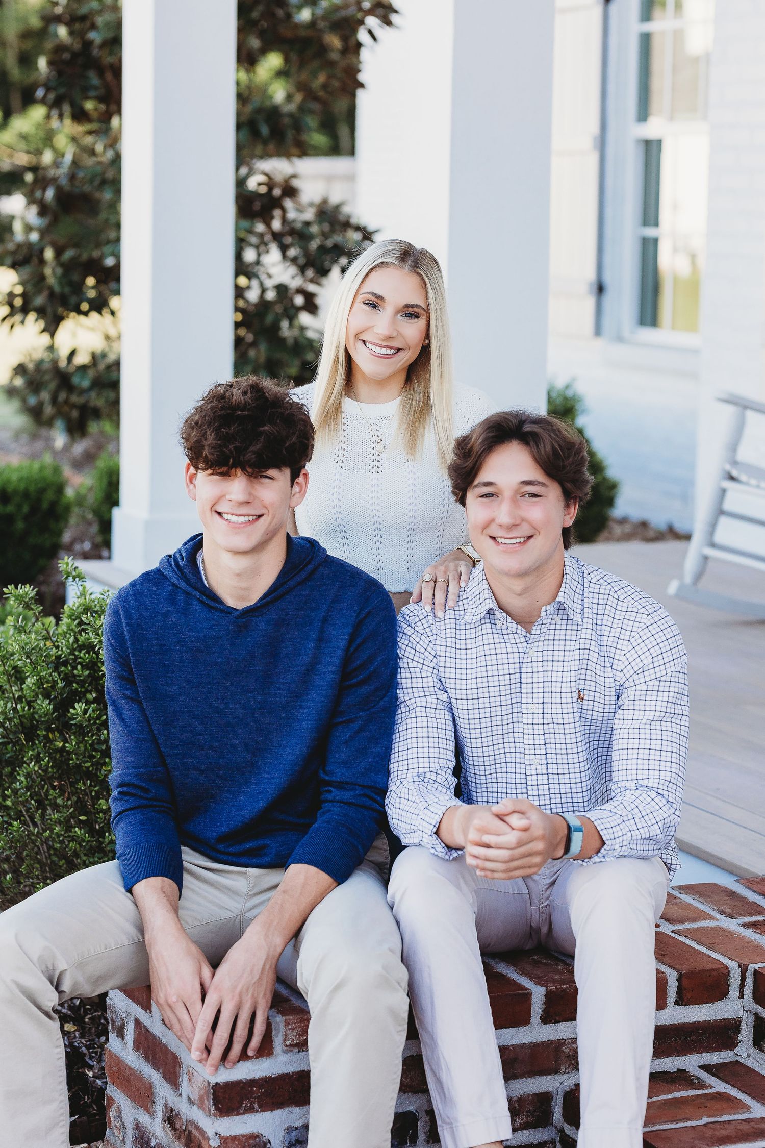 Portrait series on white porch with classic columns and brick steps.