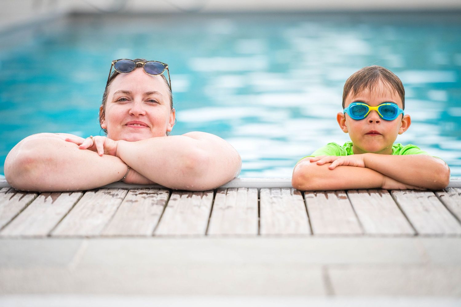 Photo tendre d'une mère et son fils au bord d'une piscine, ambiance complice et lumineuse. Photographie de famille en Ouest lyonnais.