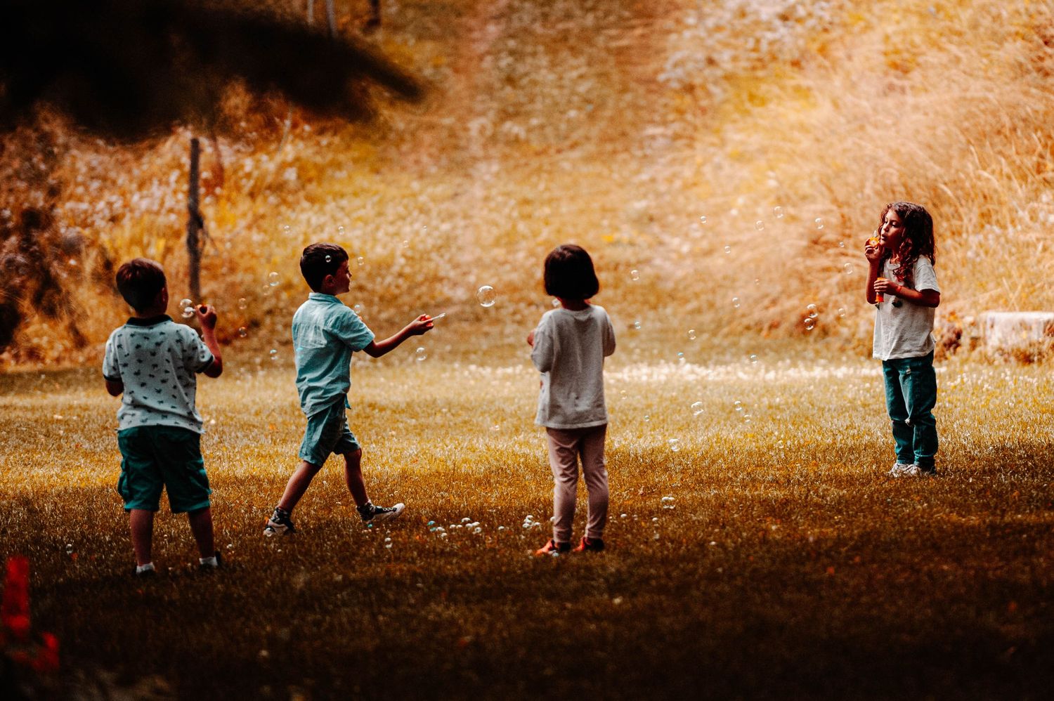 Moment de joie partagée entre enfants jouant avec des bulles, capturé en lumière naturelle par Vincent Bourdeix, photographe à l’Ouest de Ly
