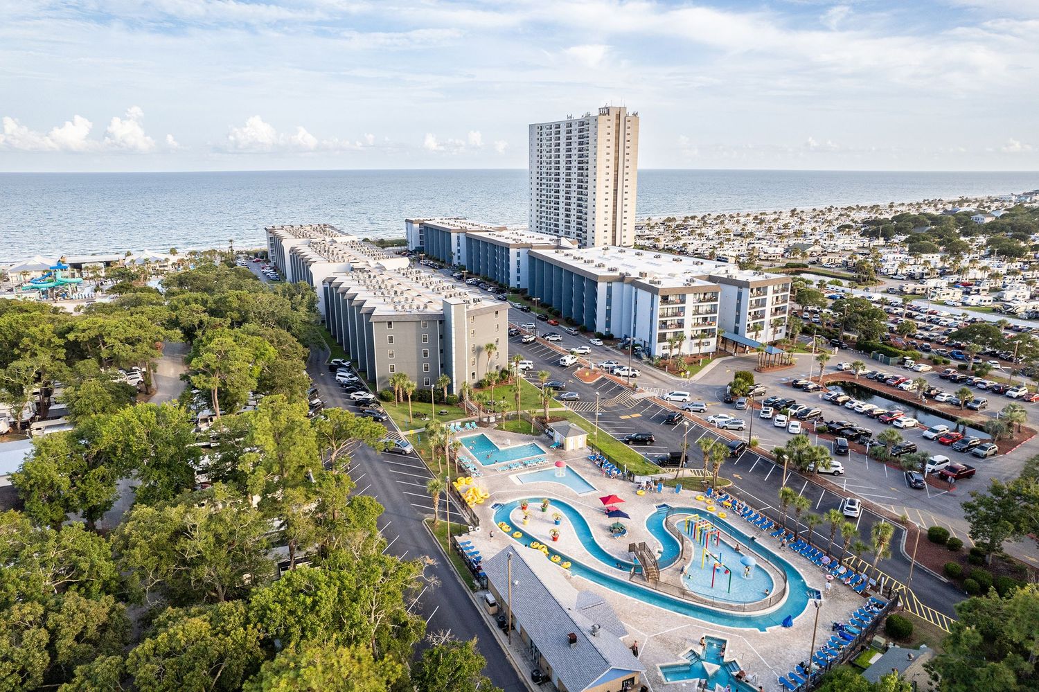 Aerial view of beachfront resort complex in Myrtle Beach featuring a water park, pool area, and high-rise condominiums near the ocean.
