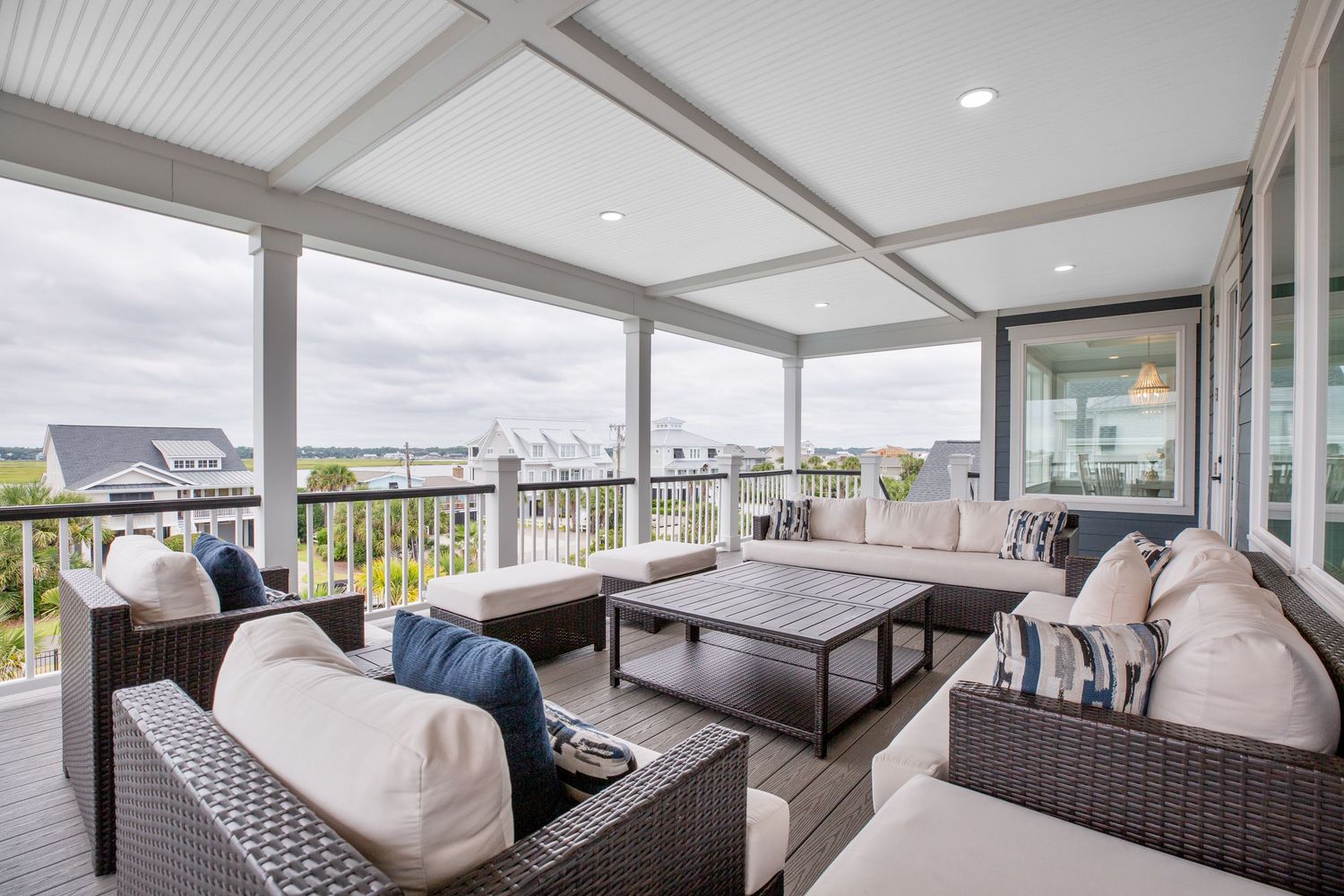 Open screened porch with wicker sectional seating and panoramic waterfront views of Murrells Inlet and Garden City, SC