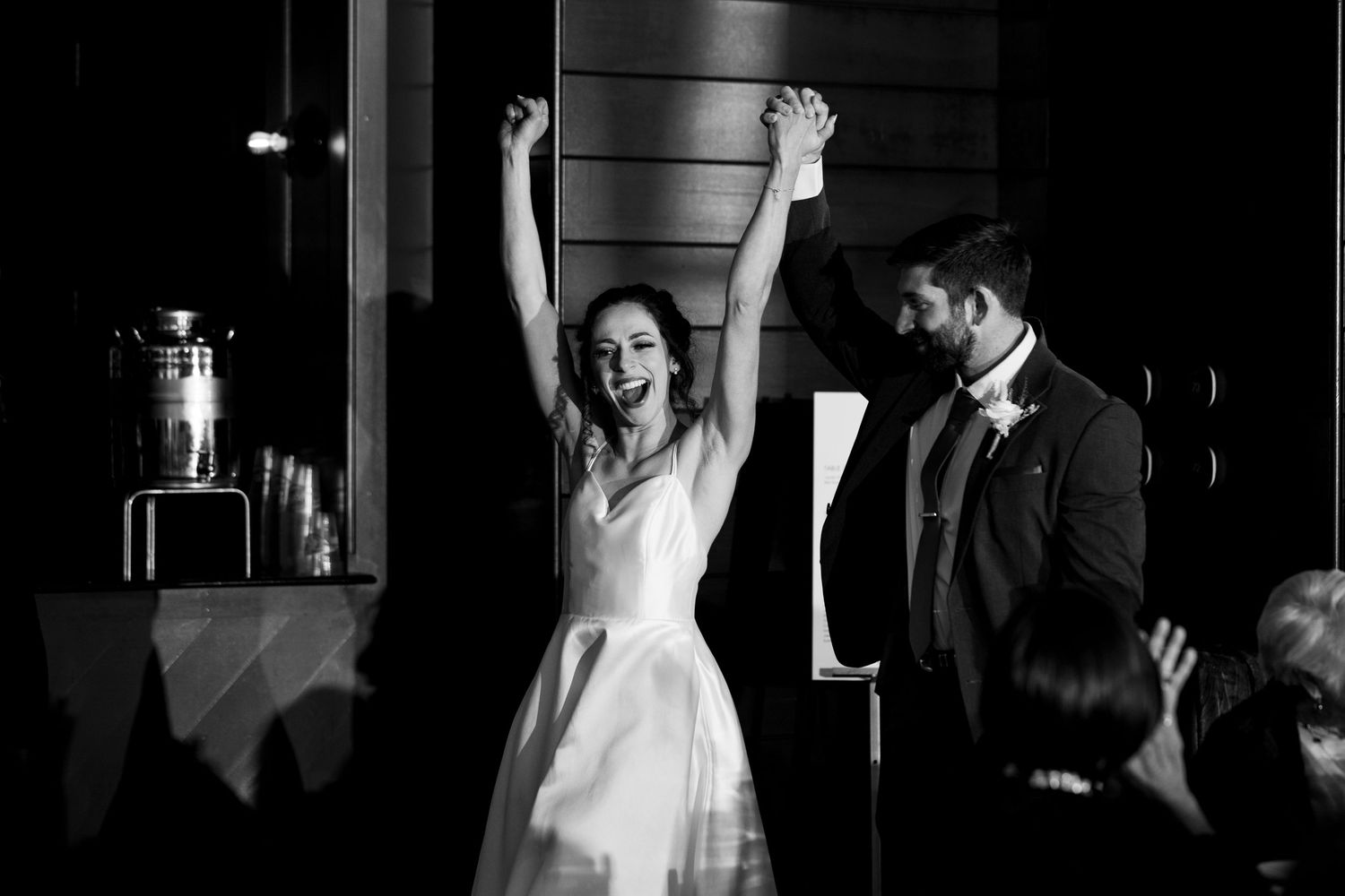 A celebratory moment captured in black and white during a wedding reception.