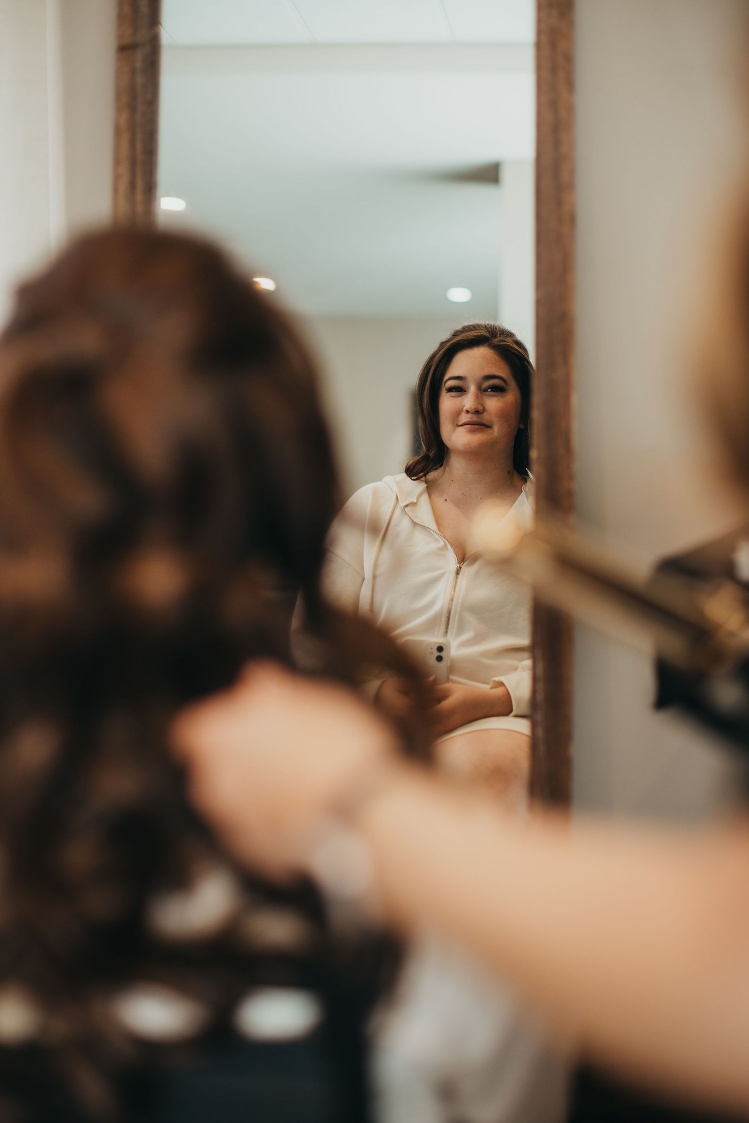 Getting ready scene with reflection in mirror showing elegant attire.