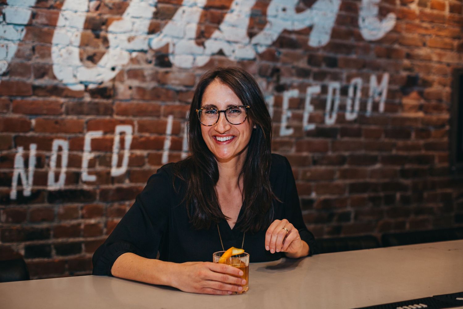 Casual meeting at industrial-style cafe with exposed brick wall and vintage signage.