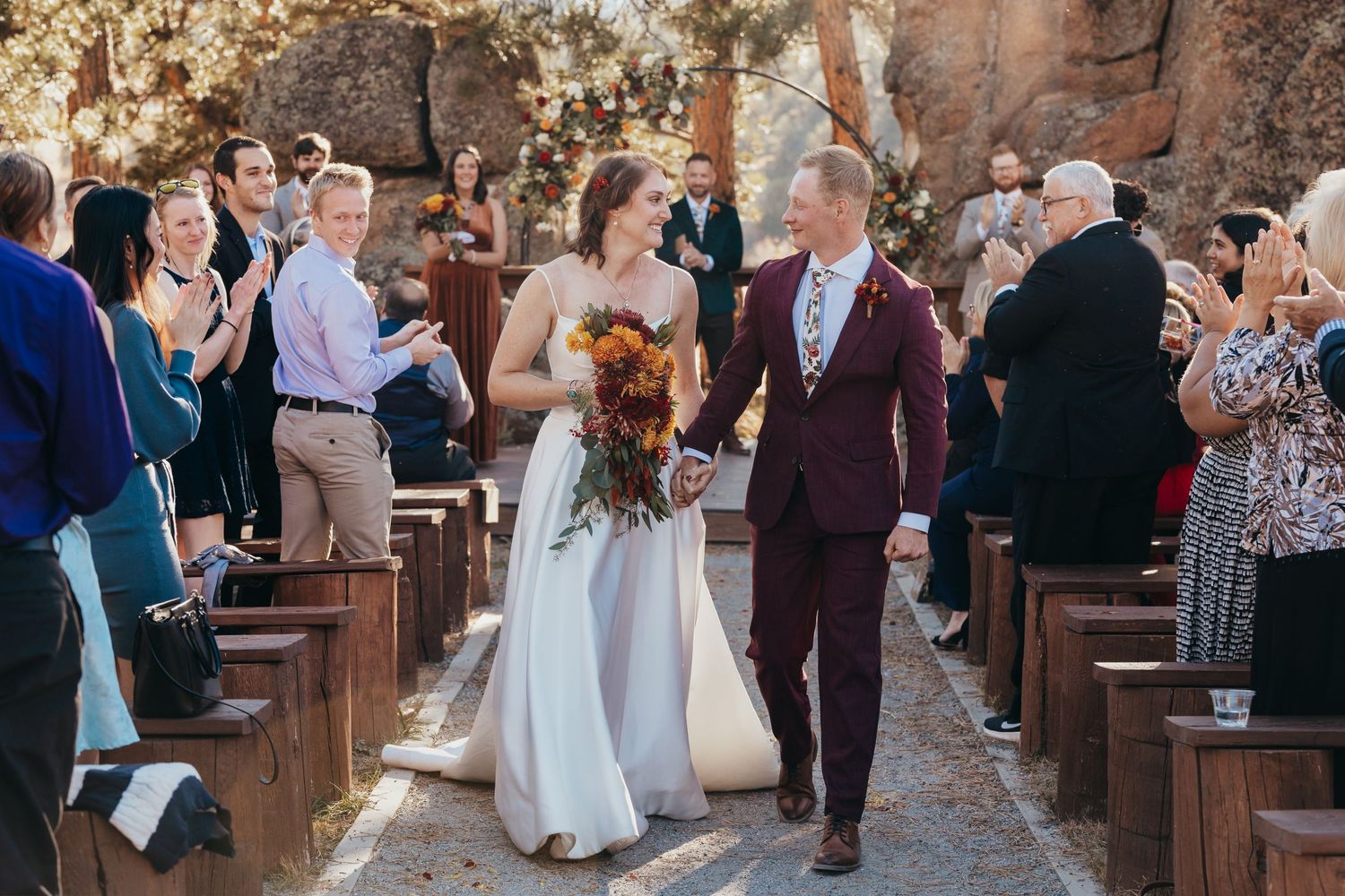 A wedding ceremony processional in a rustic stone chapel setting.