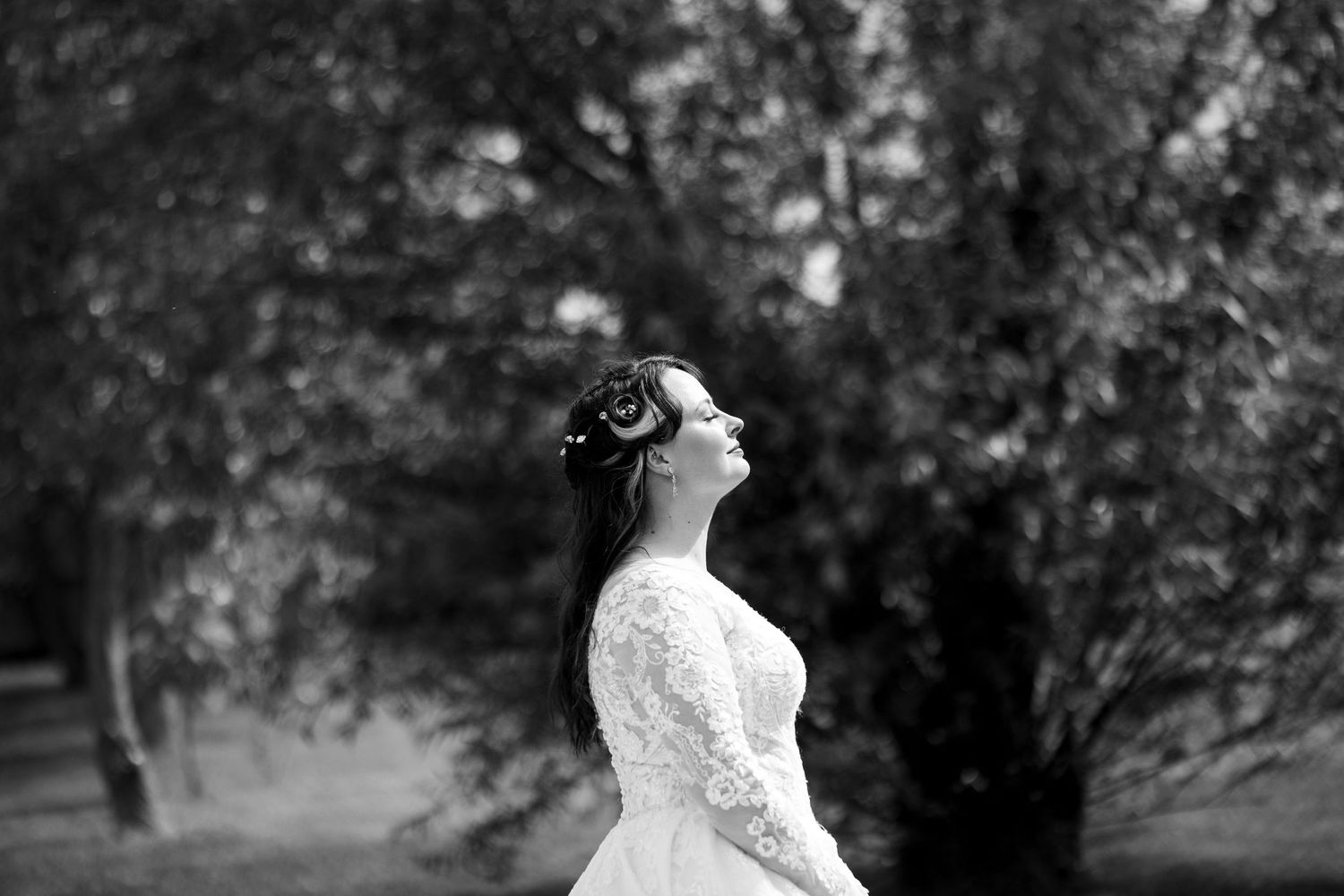 Artistic black and white profile portrait of bride in lace wedding dress.