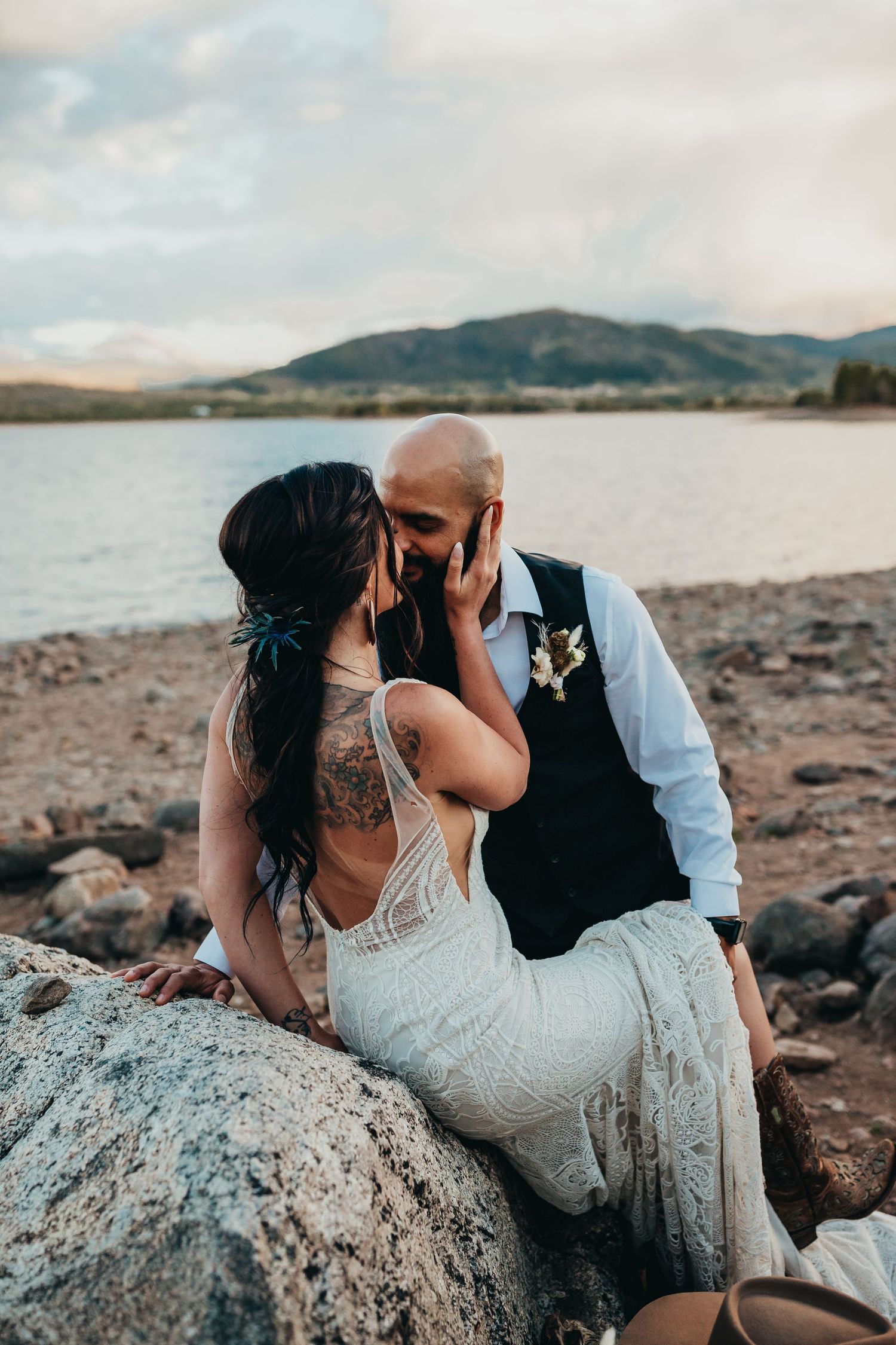 Intimate lakeside wedding portrait against mountain backdrop.