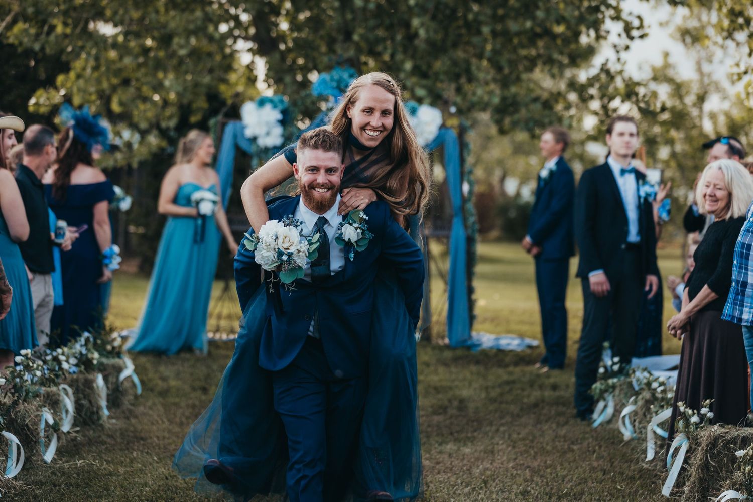 A joyful moment captured during an outdoor wedding ceremony with blue color theme.