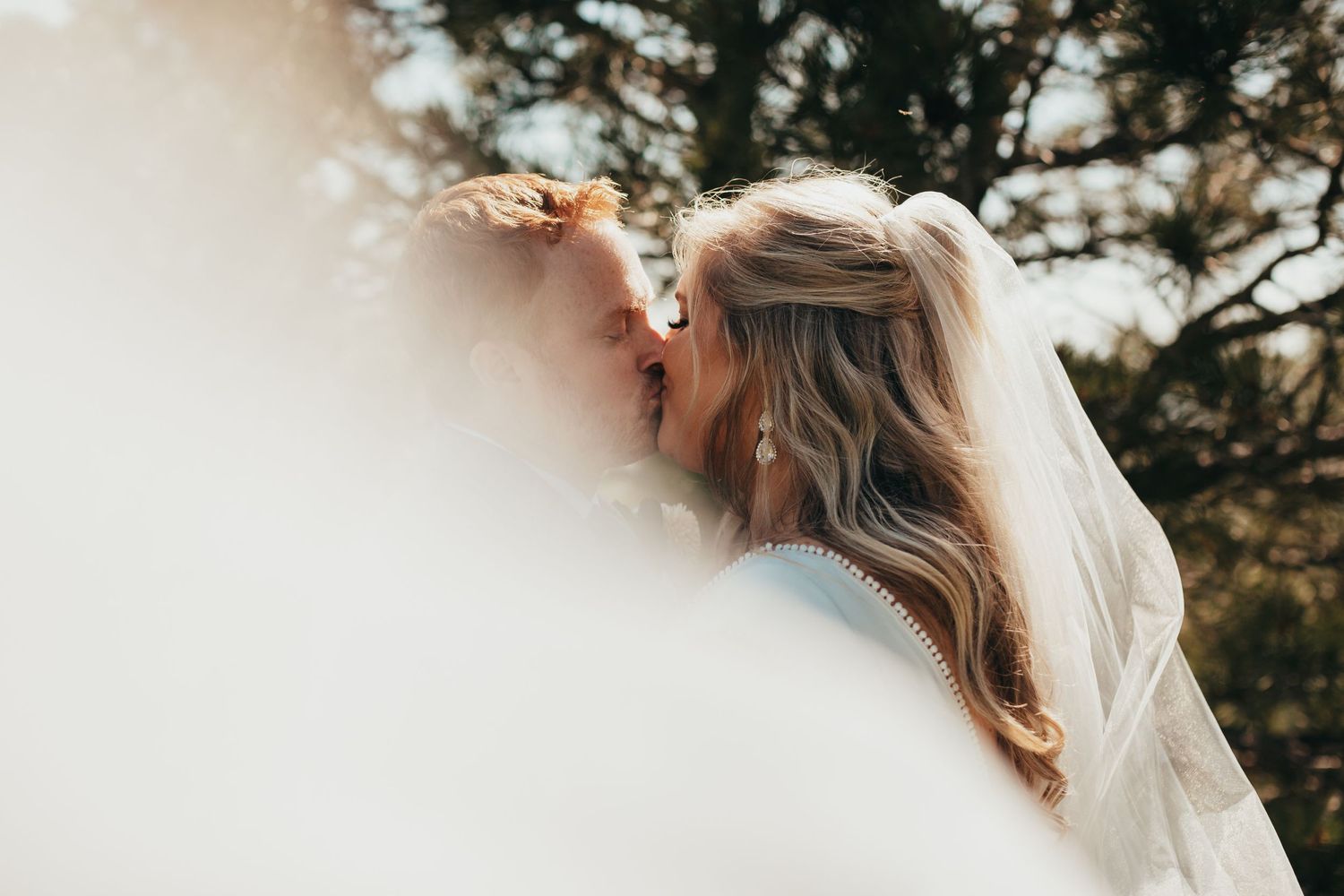 Close-up photo of bridal veil with soft bokeh effect in outdoor setting.