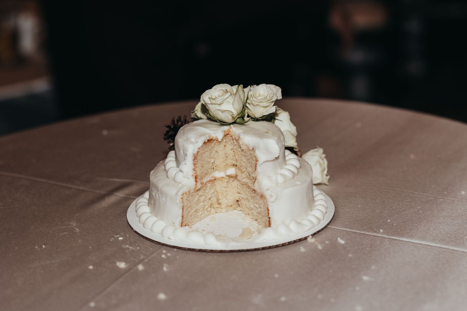 White wedding cake with decorative icing and floral accents.
