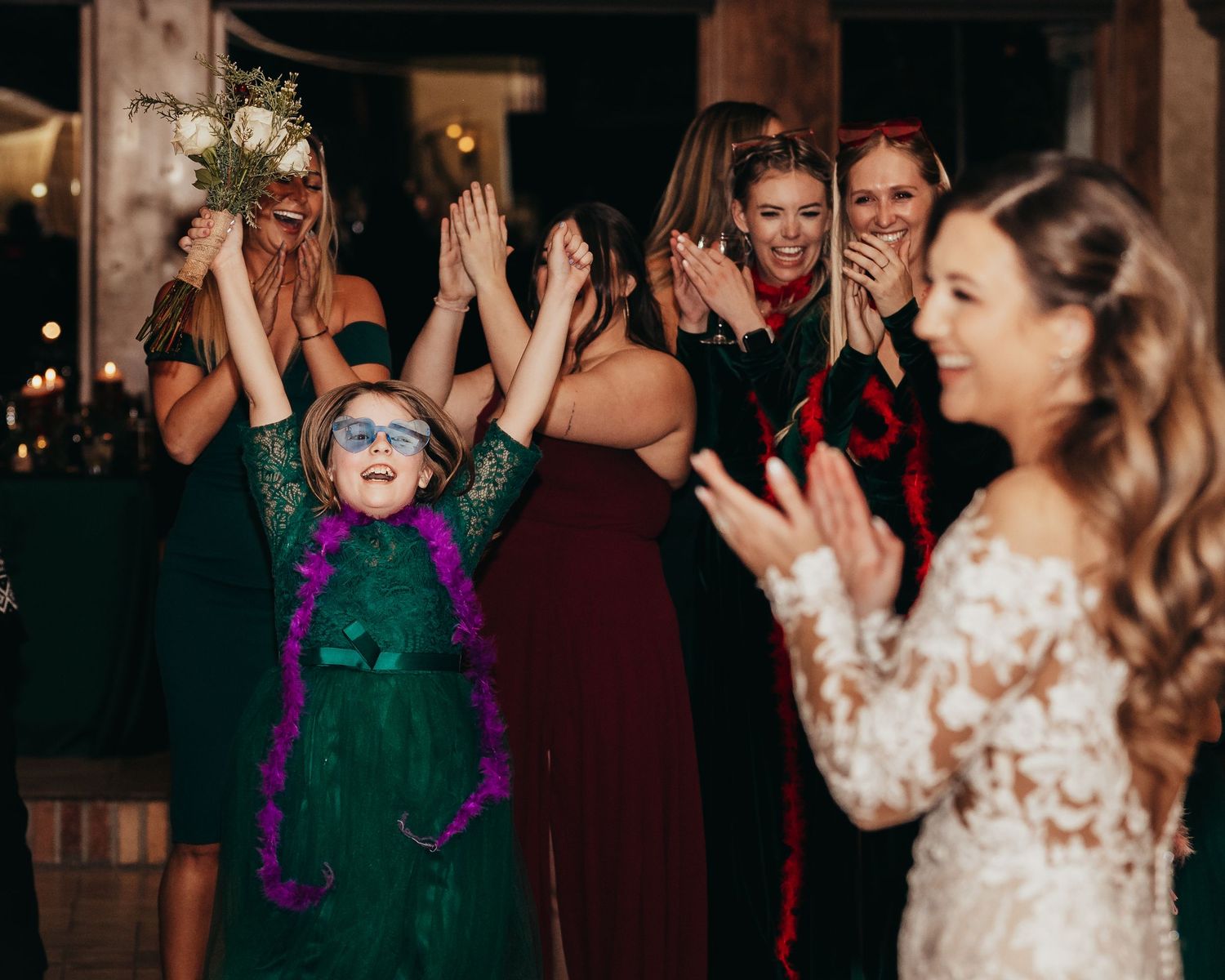 Joyful celebration with a young child wearing green amongst wedding party guests.