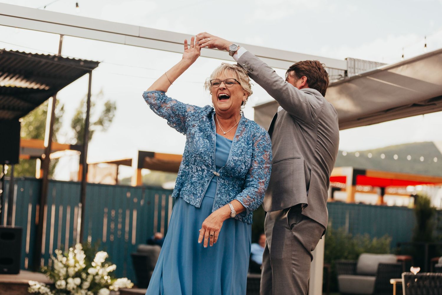 Dancing guests sharing a celebratory moment at outdoor wedding reception.