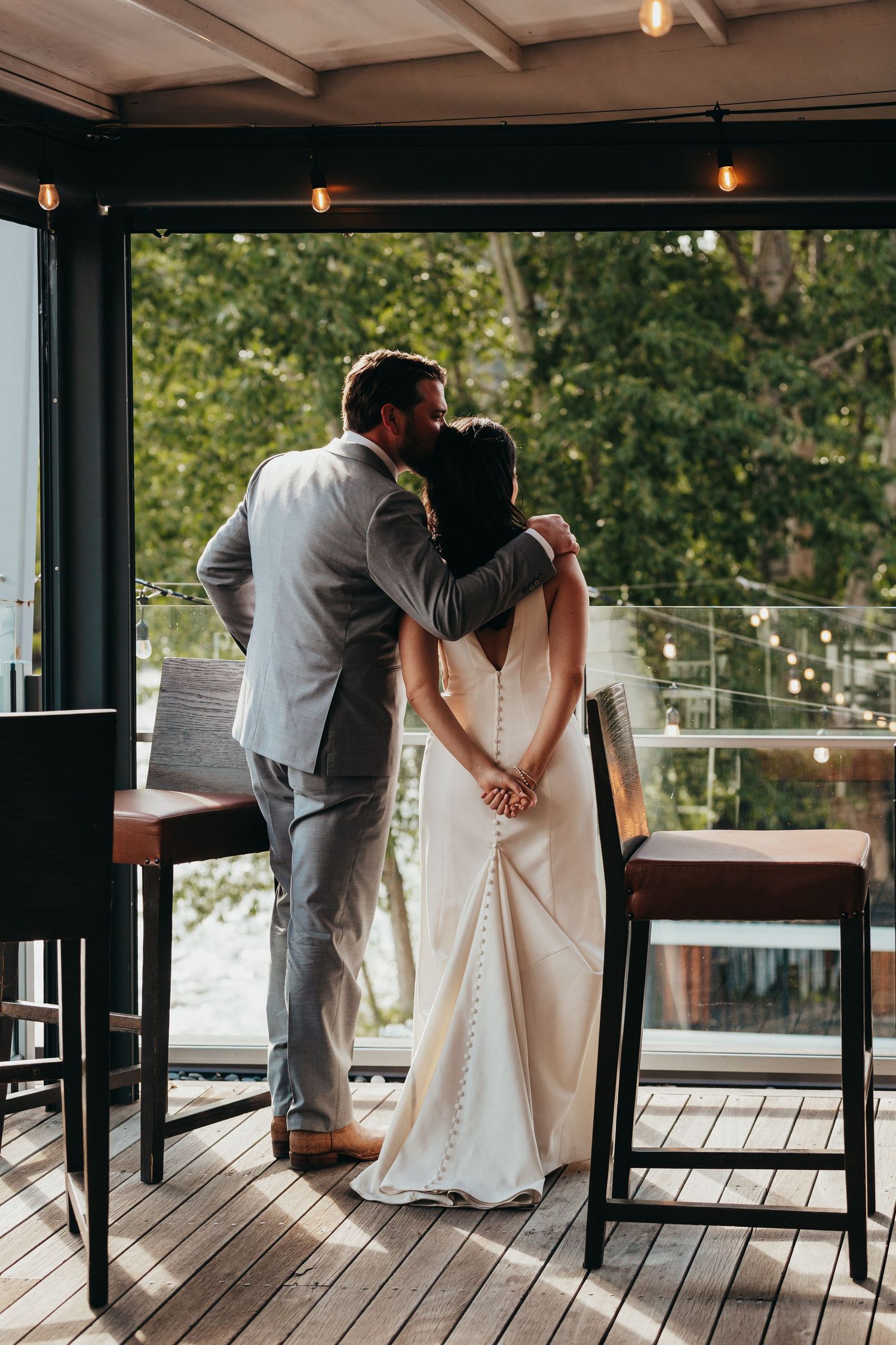 A tender moment shared on a covered deck with forest views in the background.
