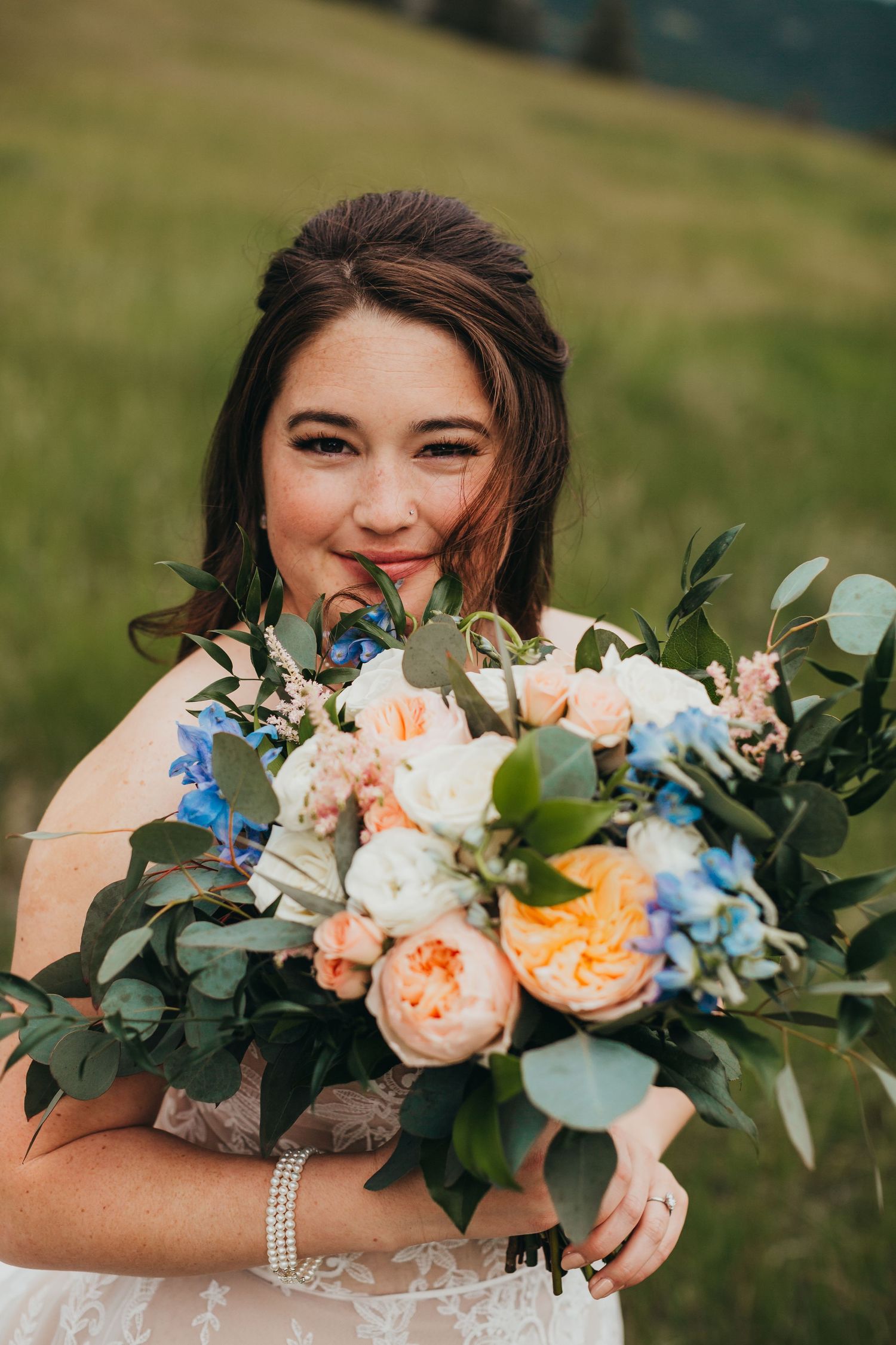 Beautiful bridal bouquet with peach roses, white peonies, and eucalyptus leaves.