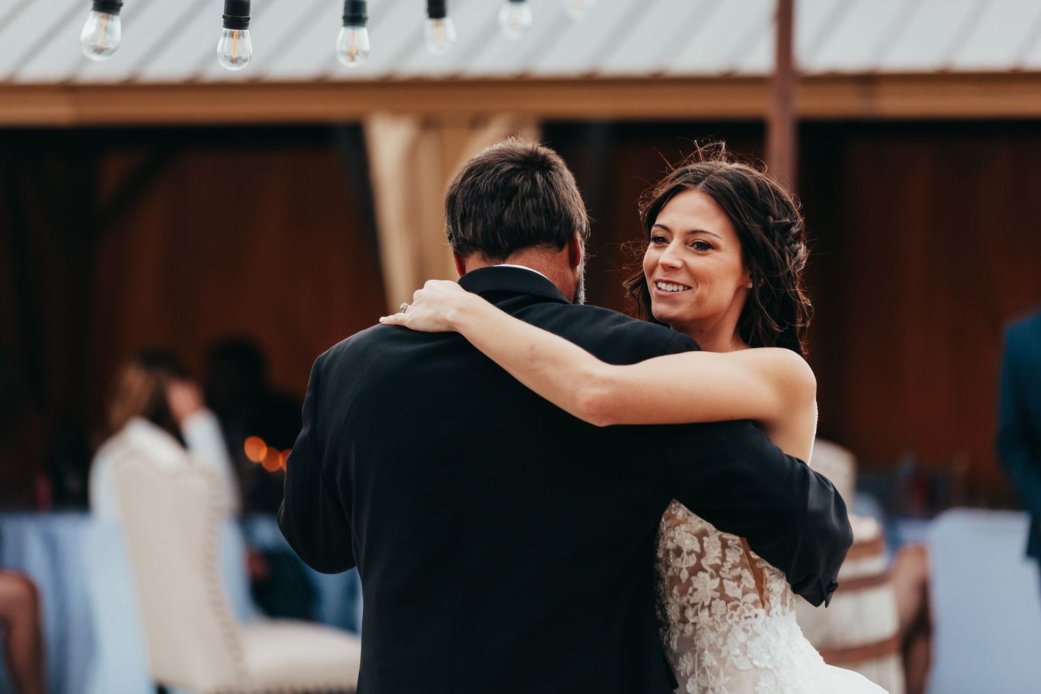 A romantic dance moment at an outdoor wedding reception.