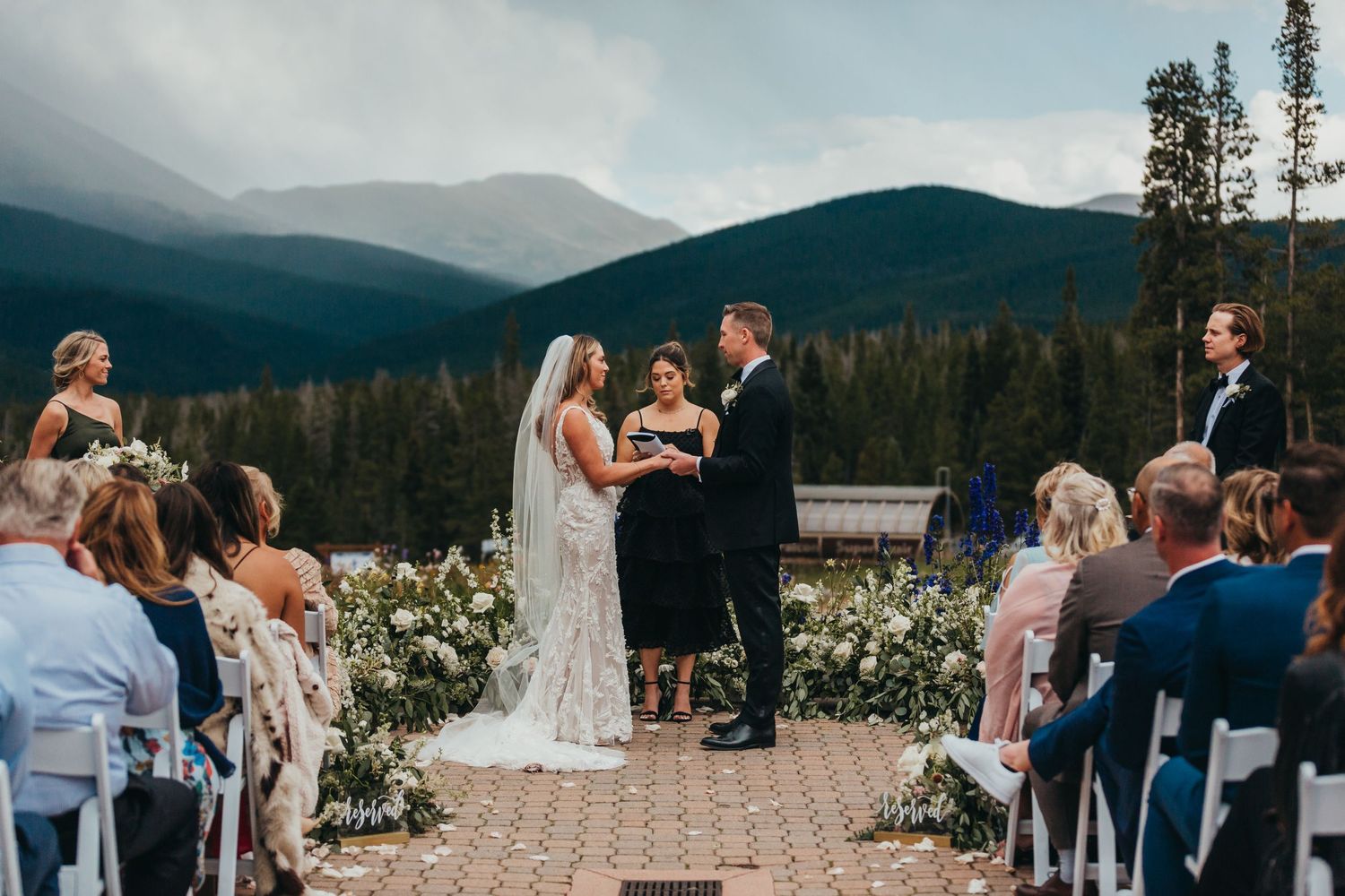 Mountain wedding ceremony with scenic forest and mountain backdrop.