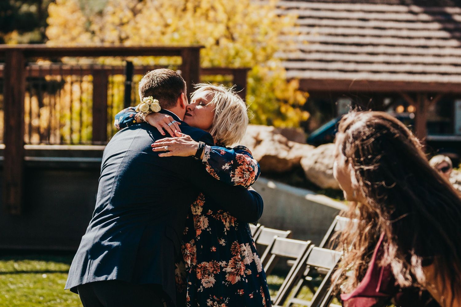 A joyful wedding celebration moment outdoors with autumn colors in the background.