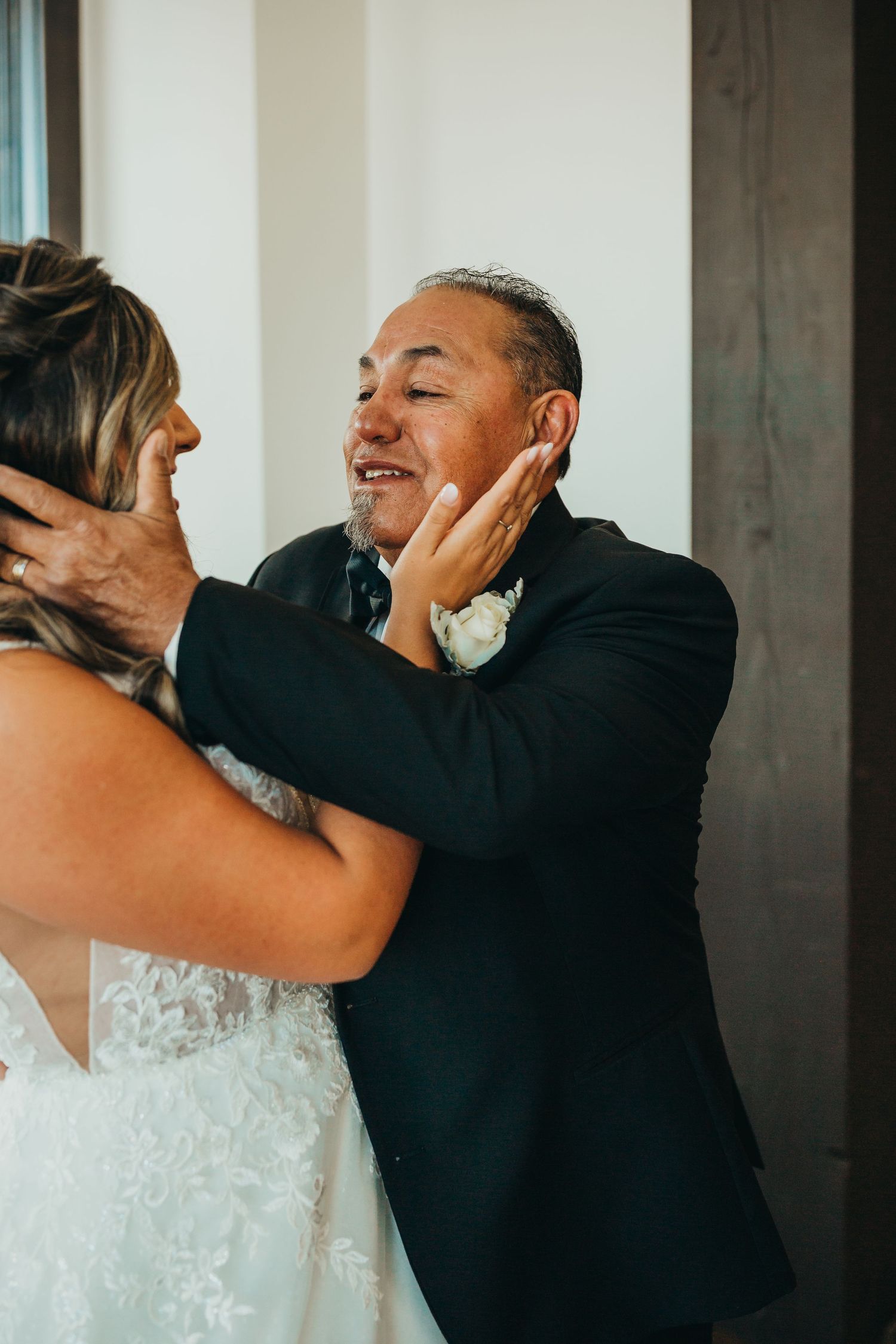 Emotional first look moment between bride and loved one during wedding preparations.