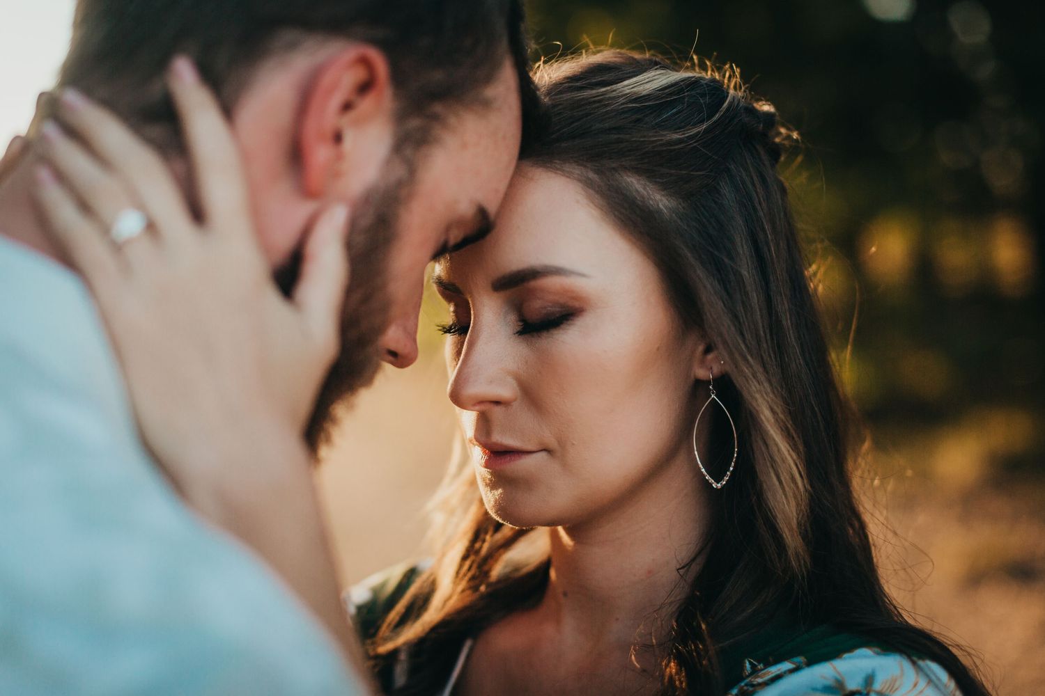 Close up shot of a tender romantic moment between two people in soft warm lighting.