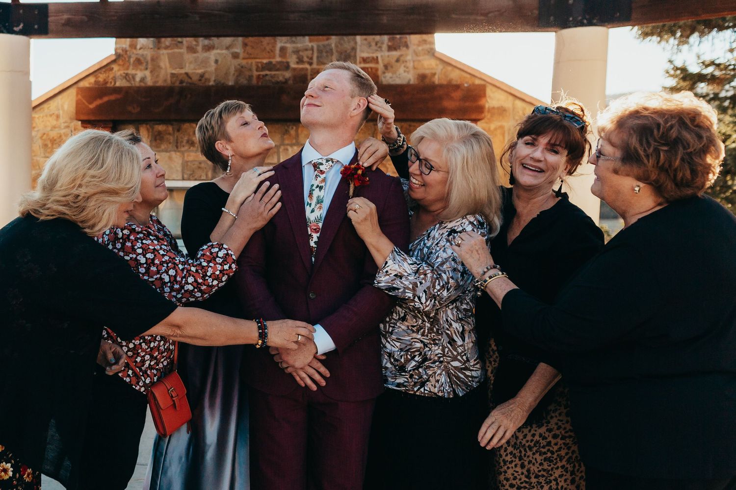 A group gathered closely together sharing a heartfelt moment at a formal event.