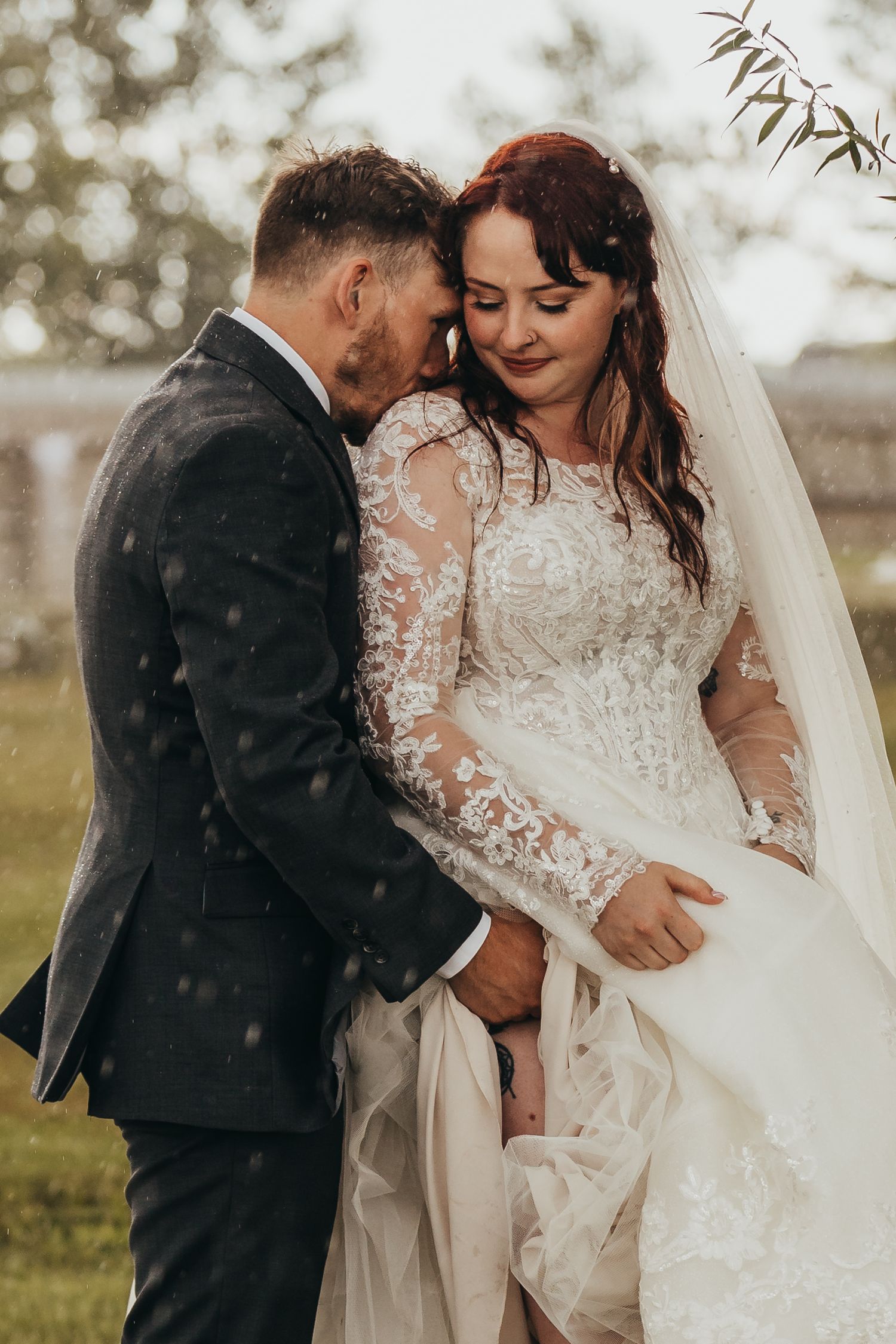 Intimate countryside wedding portrait with delicate lace details and flowing veil.