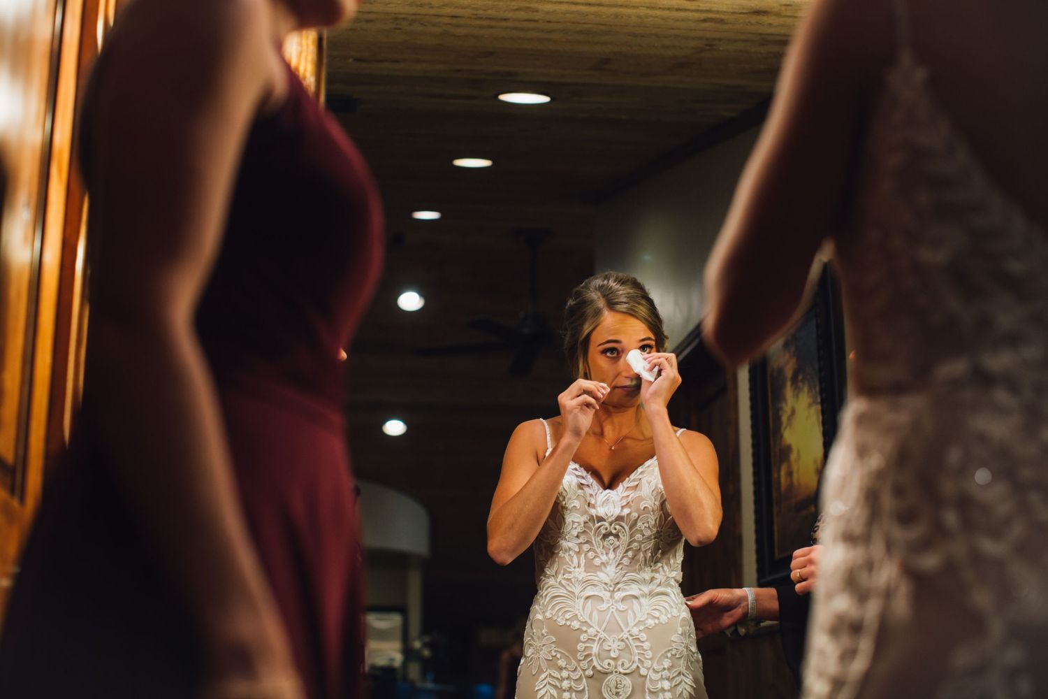 Emotional bride in white sparkly dress reacts during a wedding moment.