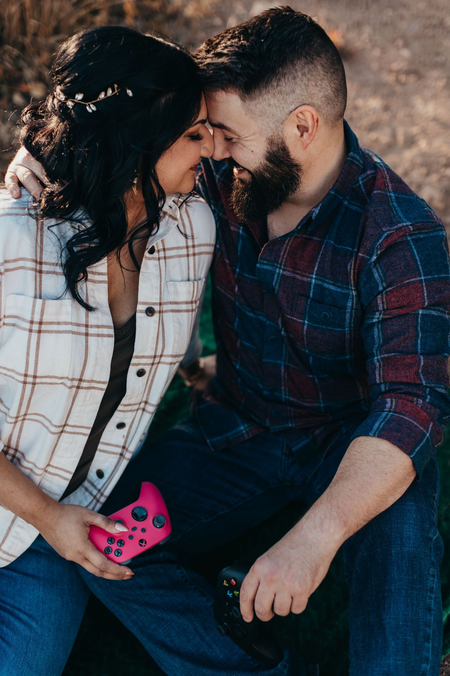 Couple laughing together during casual outdoor photoshoot with pink gaming controller.