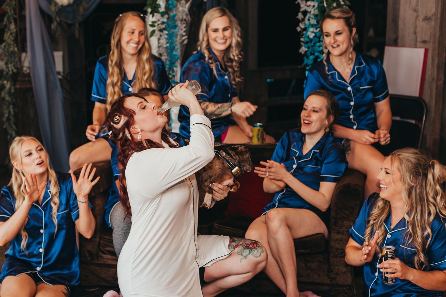 Wedding party enjoying drinks and celebrating together in matching blue outfits.